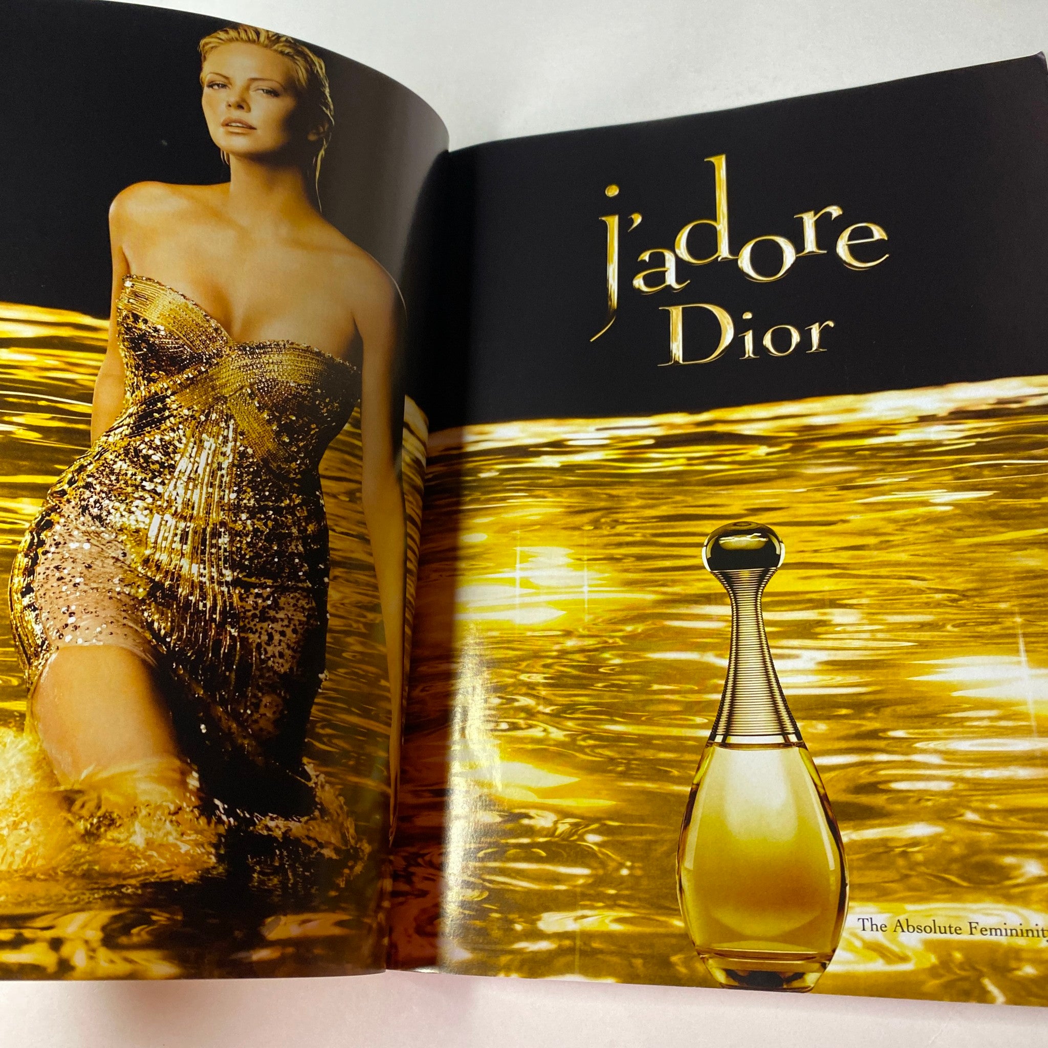 Image showcasing 'Vogue Australia Magazine June 2010' advertisement featuring a model in a shimmering gold dress promoting 'j'adore Dior' perfume, highlighting modern femininity.