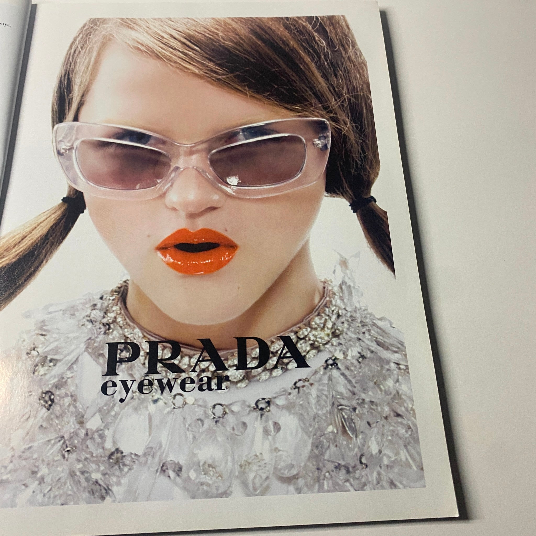 Harper's Bazaar Magazine June 2010 advertisement for Prada eyewear, featuring a model with bright orange lipstick and stylish accessories.