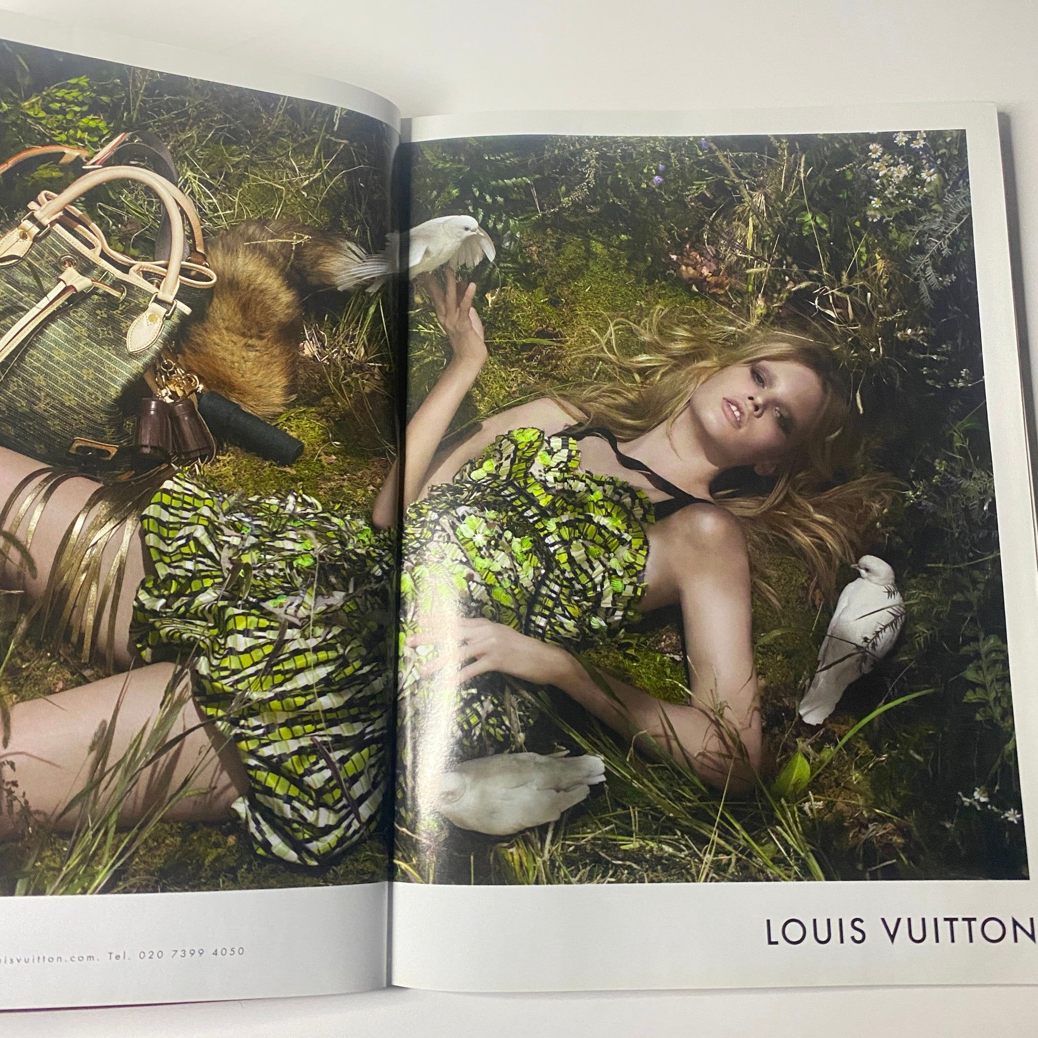 Harper's Bazaar Magazine June 2010 Louis Vuitton advertisement featuring a model in a vibrant dress surrounded by nature, showcasing luxury fashion.