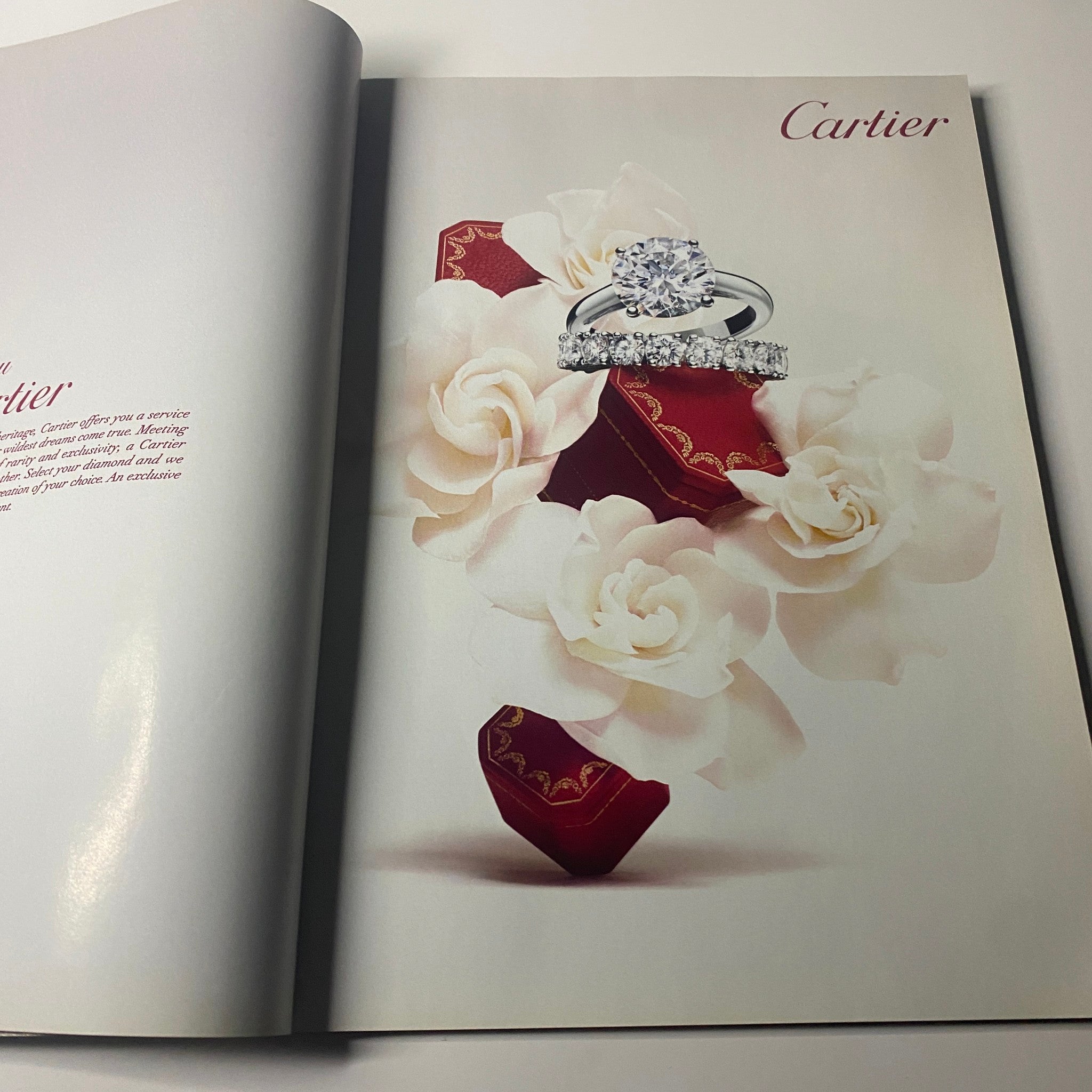 Cartier ad from Harper's Bazaar UK Magazine May 2011 displaying exquisite diamond rings positioned among elegant white flowers, representing luxury and romance.