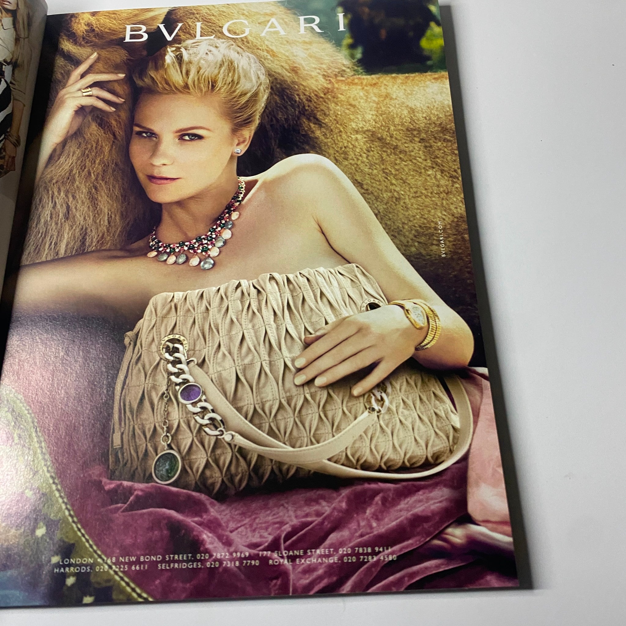 Bvlgari advertisement showcasing a model with elegant jewelry and a stylish handbag, featured in Harper's Bazaar UK Magazine July 2012.