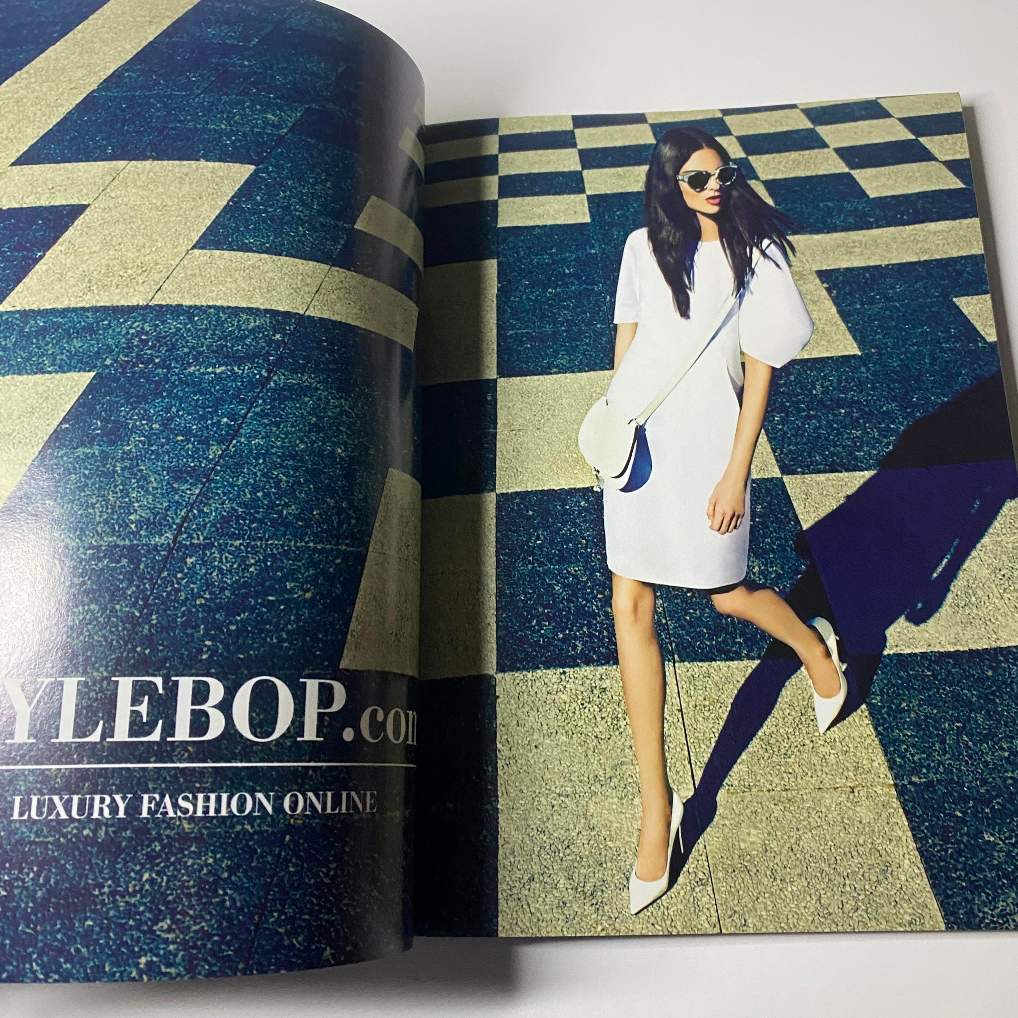 Fashion ad for Stylebop.com in Harper's Bazaar UK Magazine March 2013, featuring a model in a striking outfit against a patterned background.