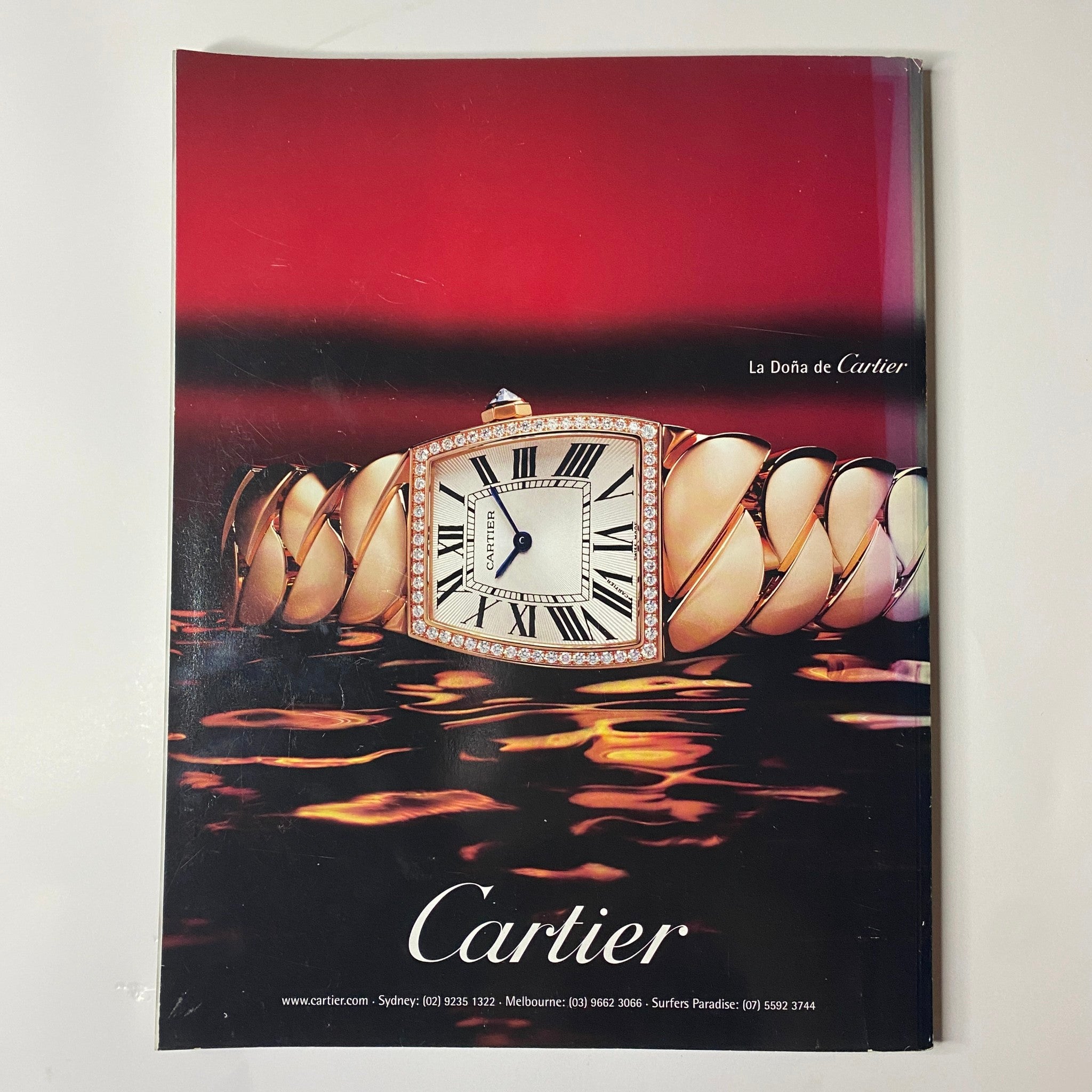 Elegant Cartier advertisement featuring a luxurious watch displayed on a lavish background, as seen in Harper's Bazaar Australia Magazine October 2006.