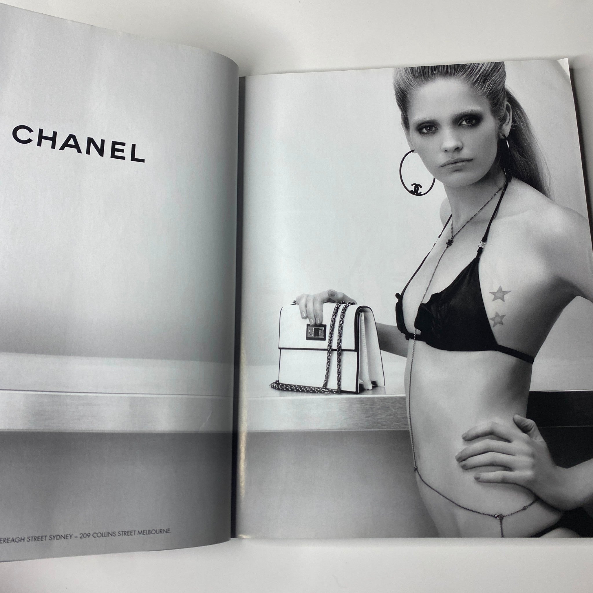 Chanel advertisement featuring a model in a black bikini posing with a handbag, showcasing the brand's elegant style. From Harper's Bazaar Australia Magazine, December 2008, Nicole Kidman Cover (No Label, VG Condition).