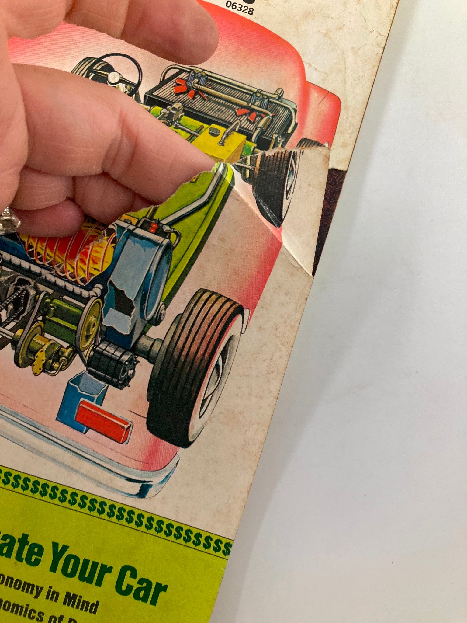 Hand pointing at the rear section of the front cover of VTG Mechanix Illustrated Magazine May 1976, emphasizing the steam engine feature.