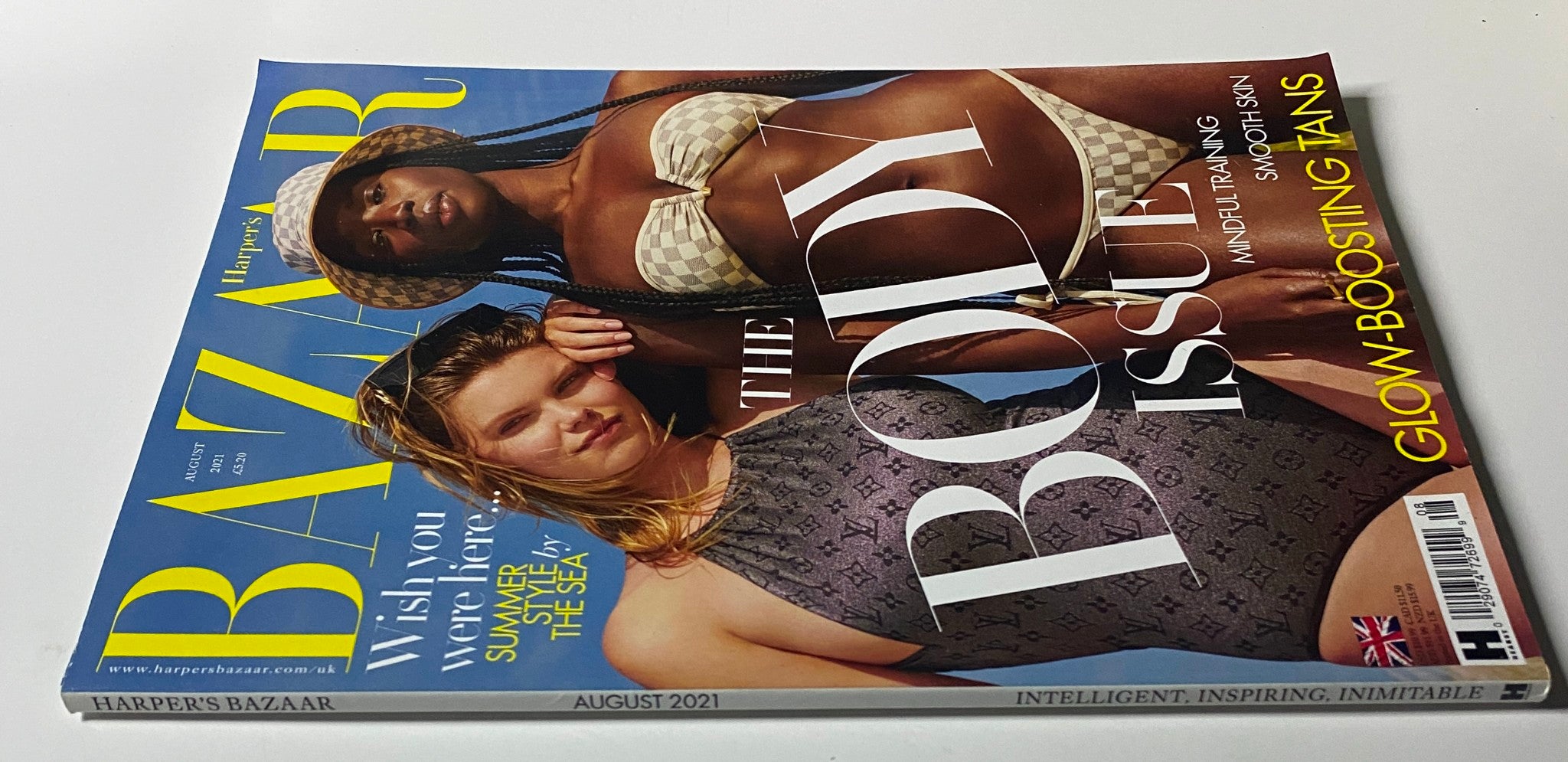 Harper's Bazaar UK Magazine August 2021 Cover with models Molly Constable and Seynabou Cissé showcasing summer fashion in a beautiful beach setting.