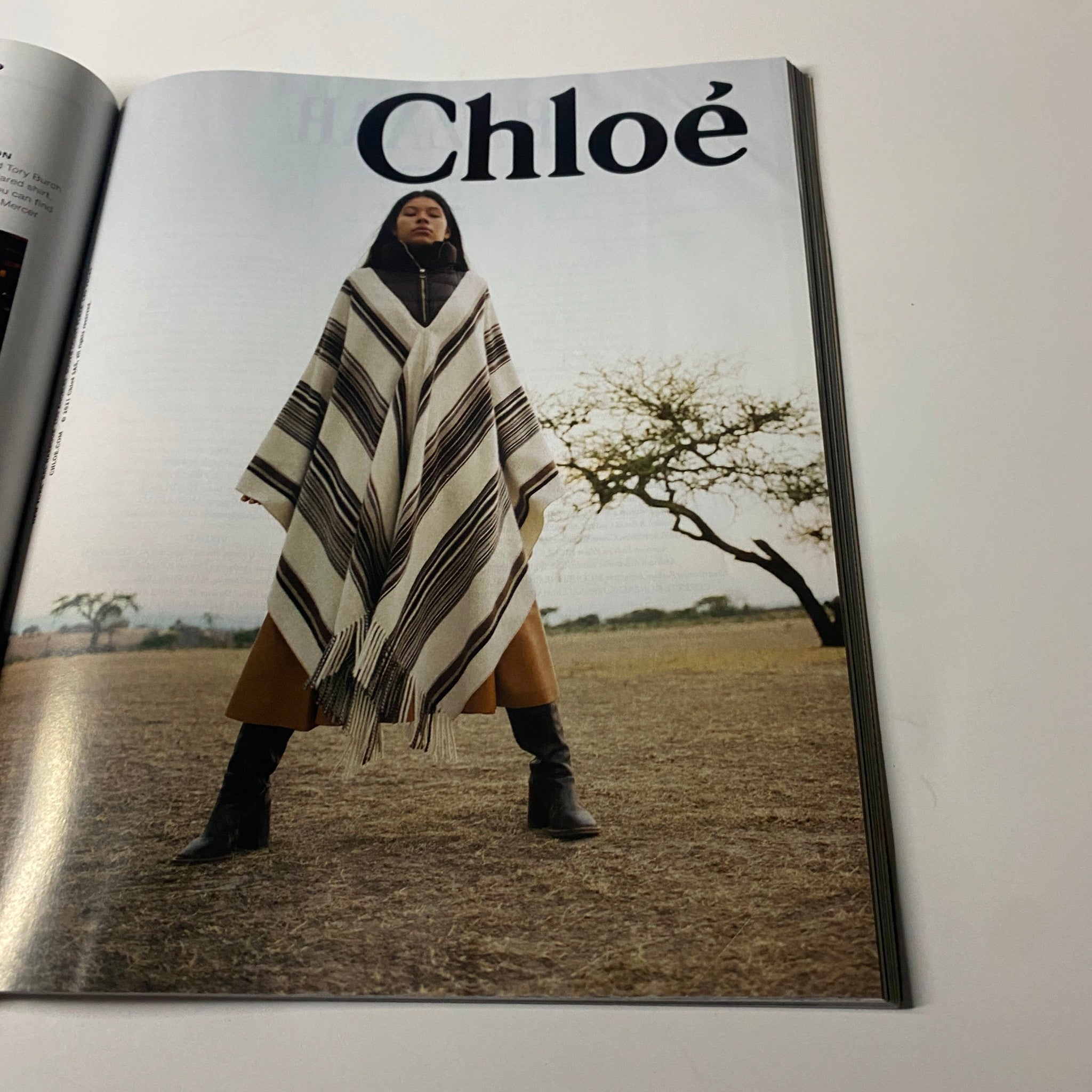 Fashion spread from Harper's Bazaar Magazine September 2021 highlighting a model in a stylish Chloé poncho set against a nature backdrop.