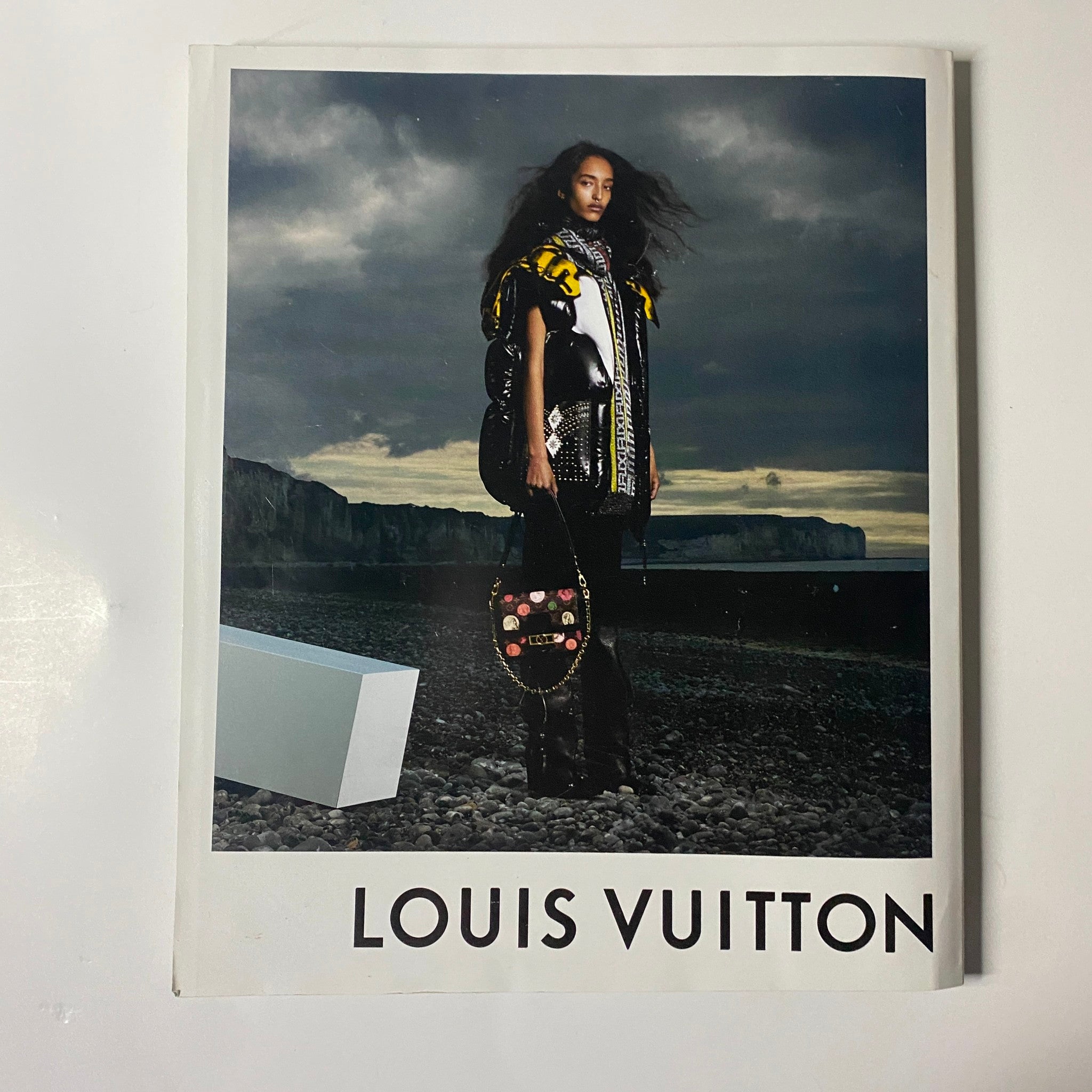 Fashion image from Harper's Bazaar Magazine September 2021 displaying a model with a Louis Vuitton bag against a coastal landscape.