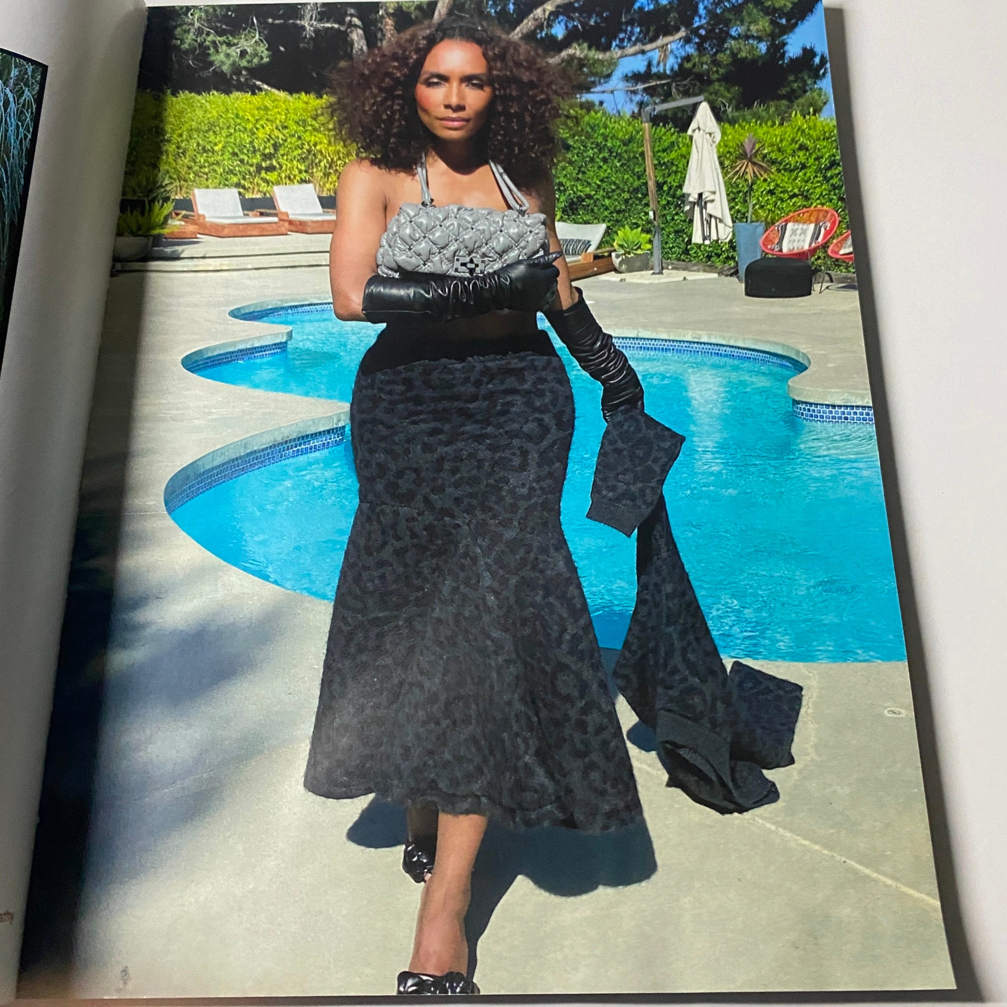 Stylish photo from the October 2020 Vogue Magazine, displaying a model in a chic outfit by a pool, reflecting contemporary fashion trends.