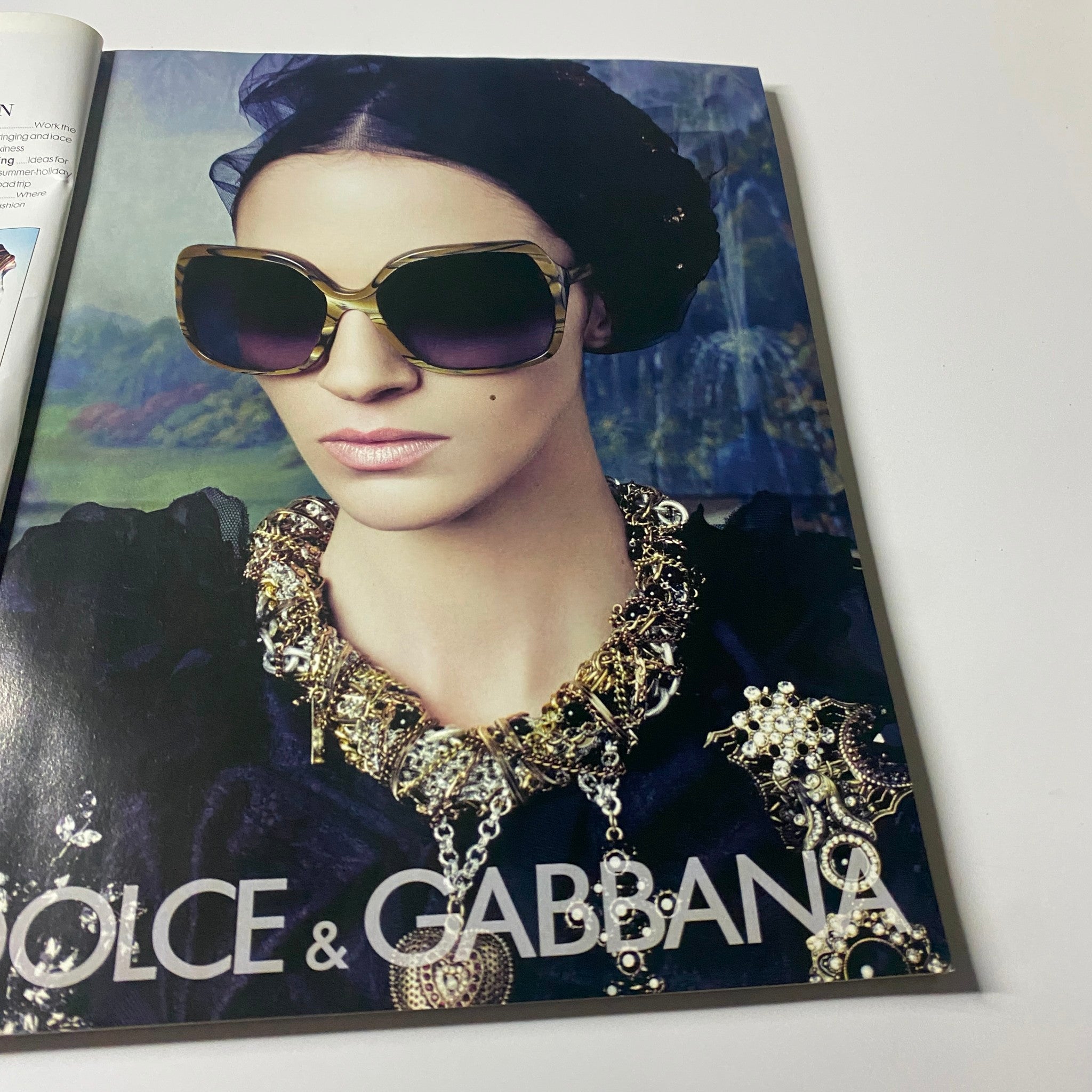 Elle UK Magazine June 2009 Reese Witherspoon Cover: A model wearing oversized sunglasses and a statement necklace, elegantly styled for a luxury fashion spread featuring Dolce & Gabbana.