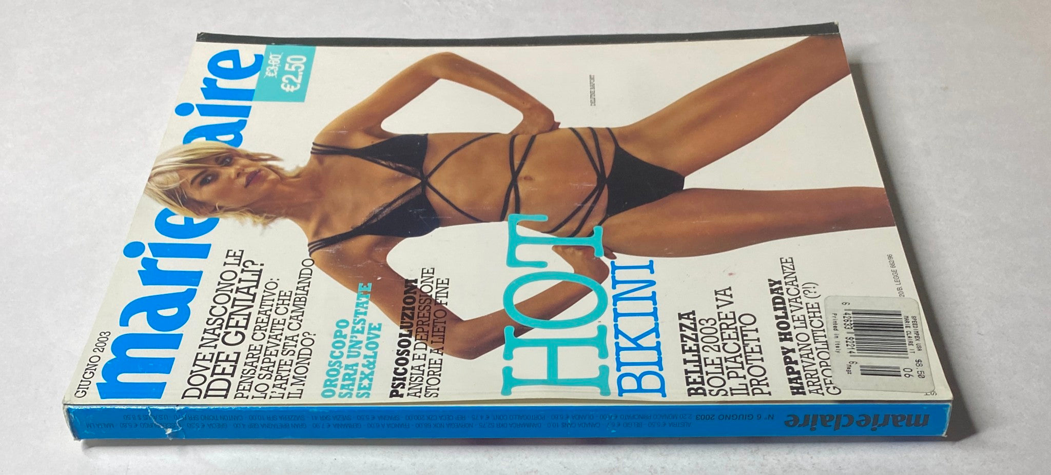 Side view of the June 2003 issue of Marie Claire Italia Magazine showcasing Delfine Bafort on the cover wearing a black bikini, emphasizing the magazine's focus on fashion and lifestyle.