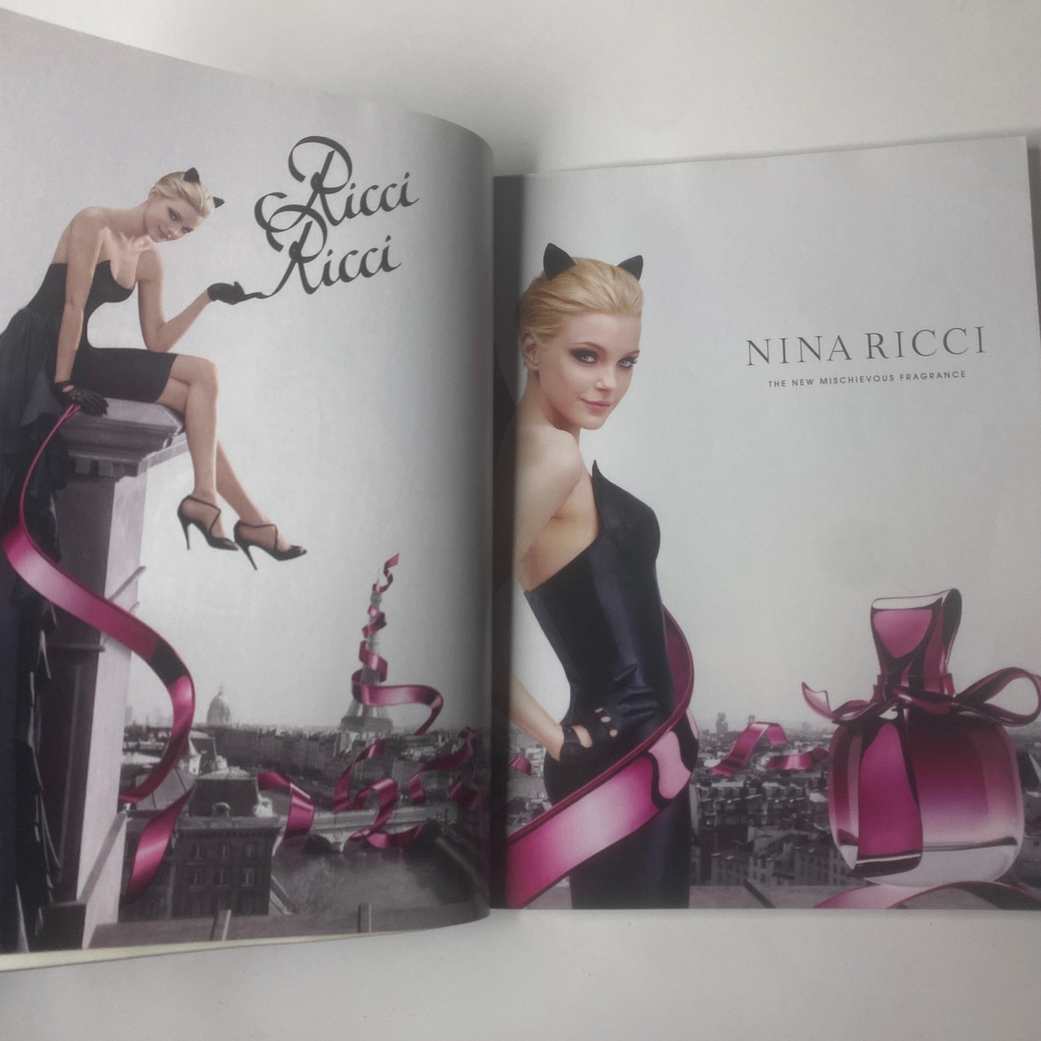 Elle UK Magazine November 2009 advertisement for Nina Ricci fragrance featuring a model in a stunning black dress.