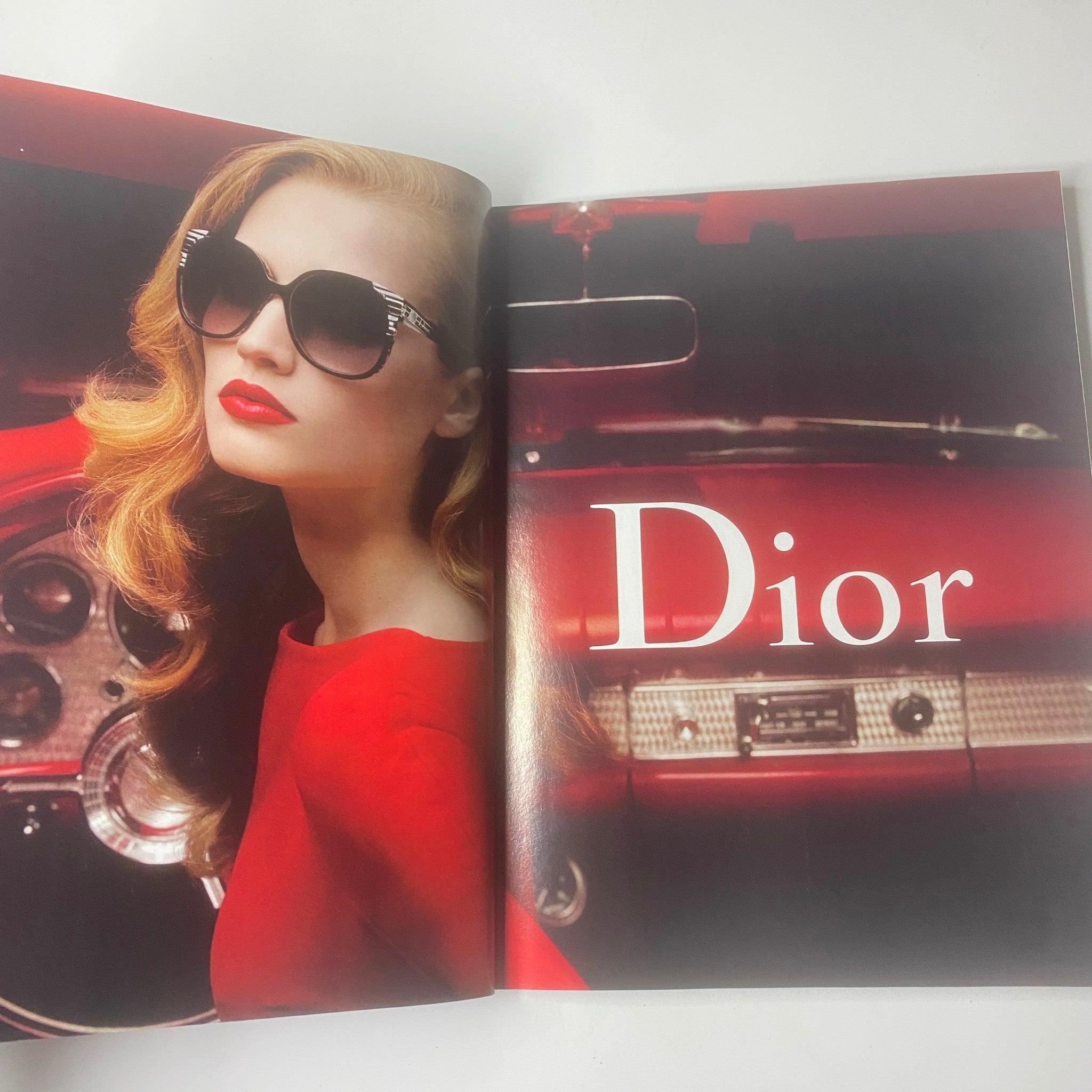 Elle UK Magazine November 2009 advertising spread for Dior showcasing a model in bold red lipstick and stylish eyewear.