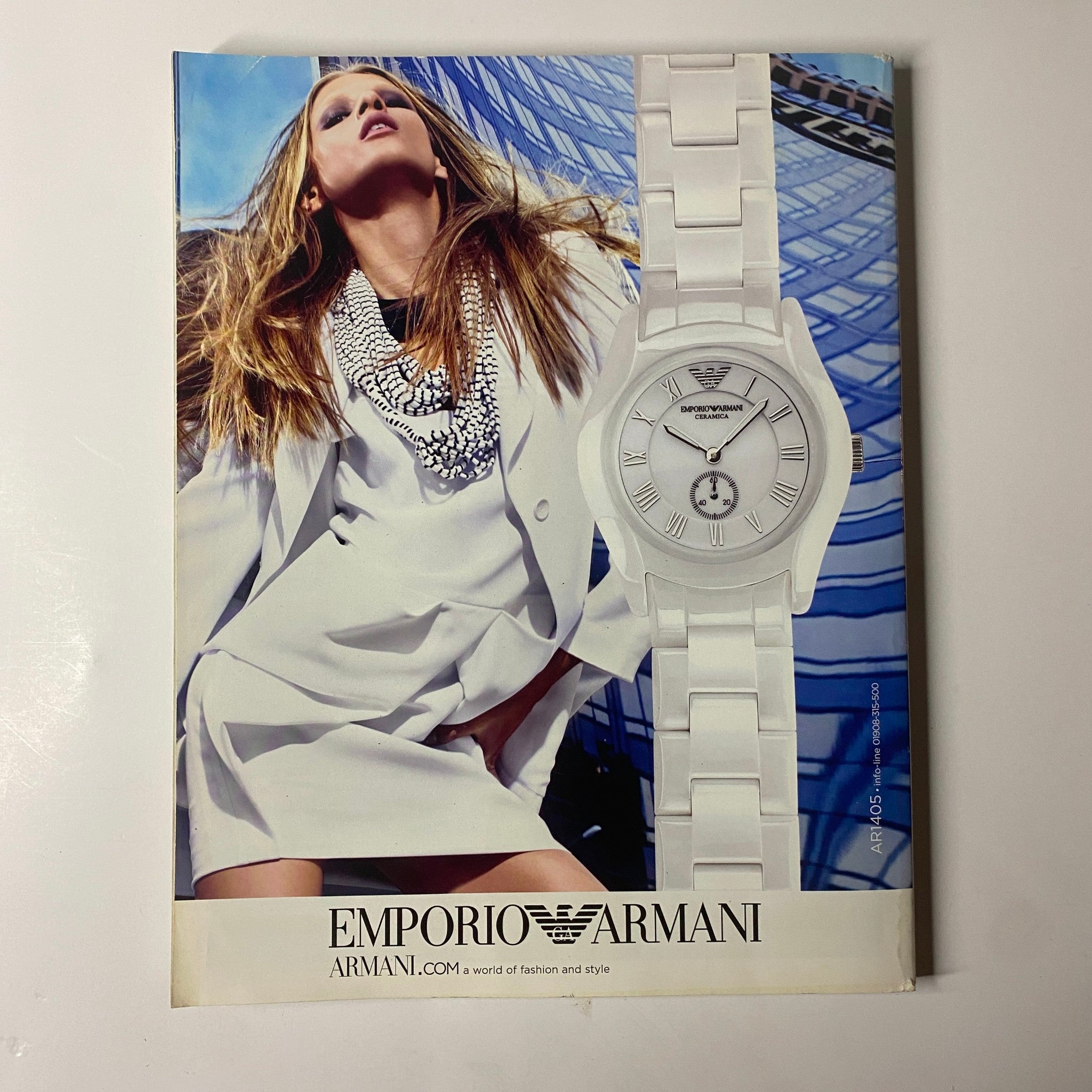 Emporio Armani advertisement from Elle UK Magazine May 2010 featuring a model wearing striking white attire with a stylish watch.