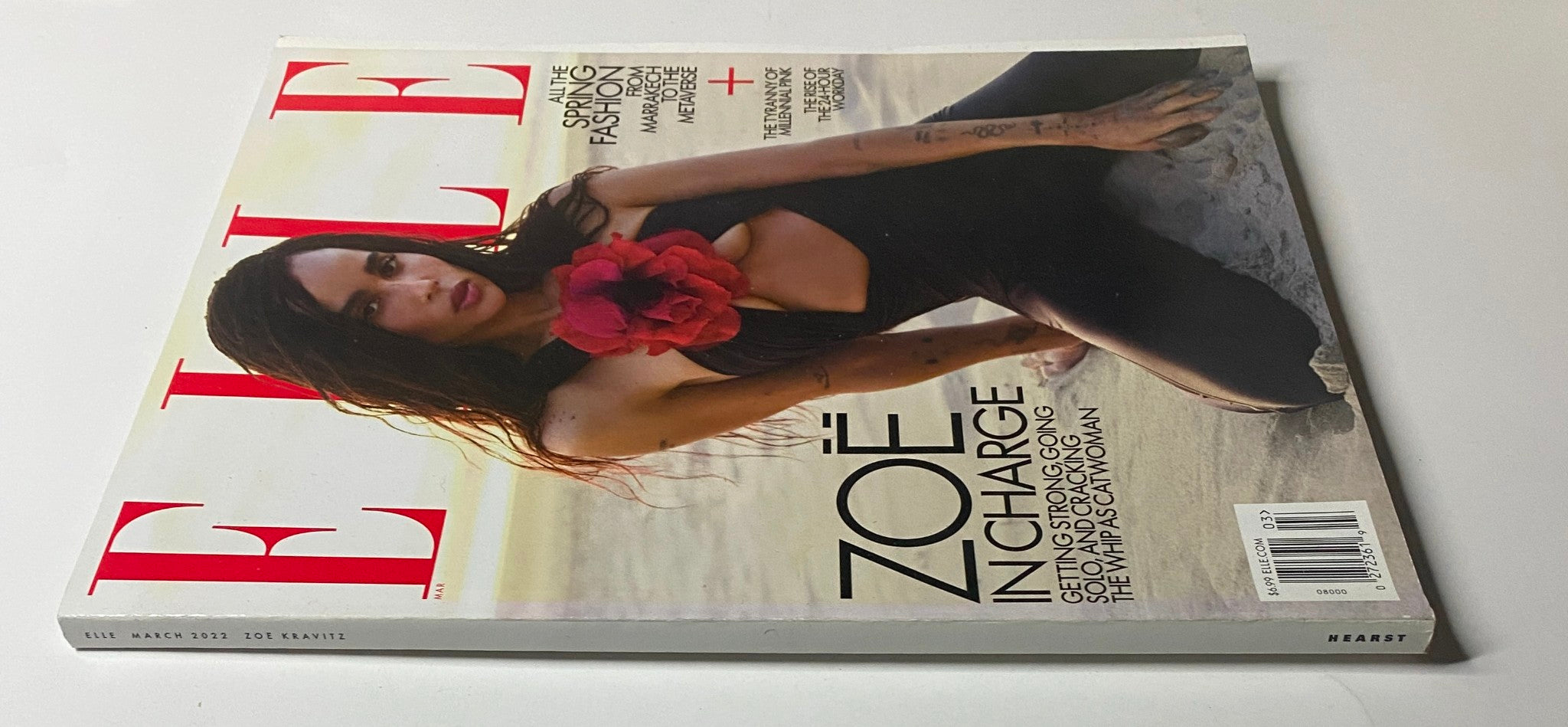 Elle Magazine March 2022 cover showing Zoë Kravitz with a striking pose, wearing a black outfit and a bold red flower, highlighting the theme of empowerment.