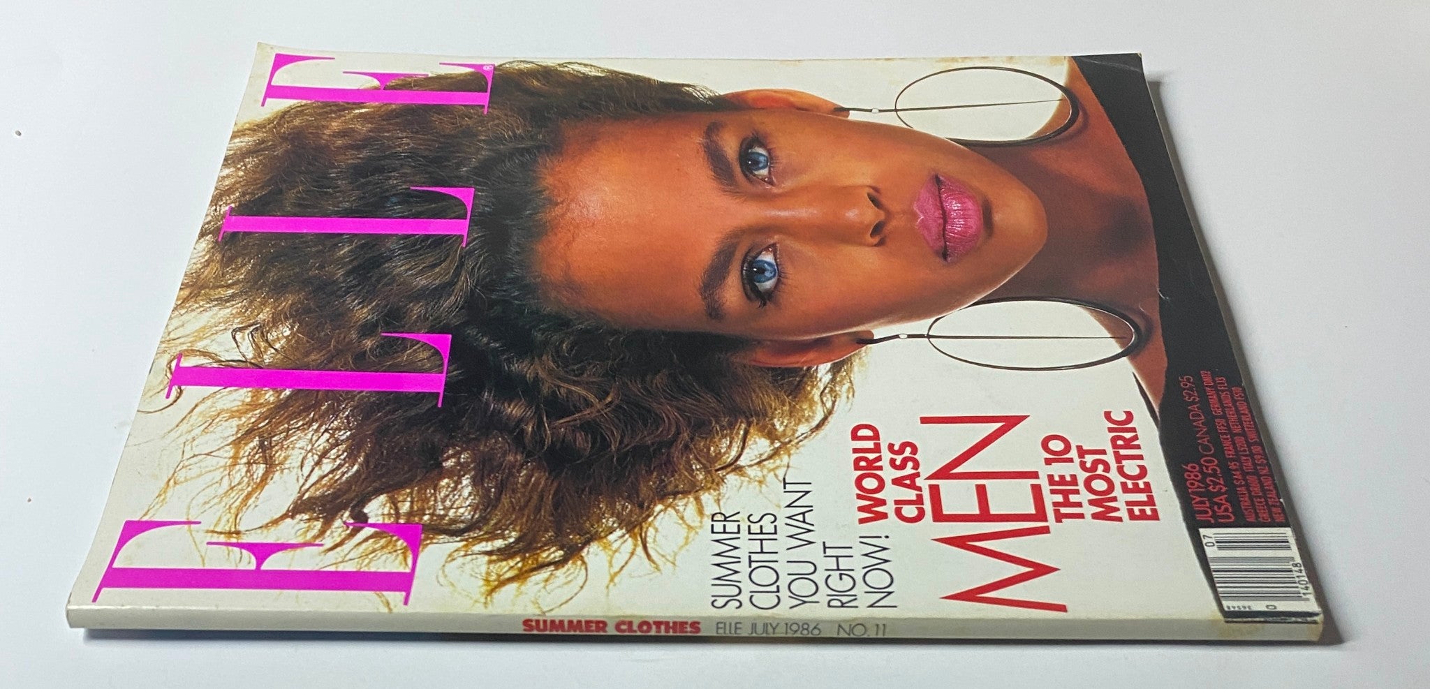 Elle Magazine July 1986 No. 11 cover showcasing a close-up of a model with voluminous hair and striking makeup, emphasizing summer fashion trends.