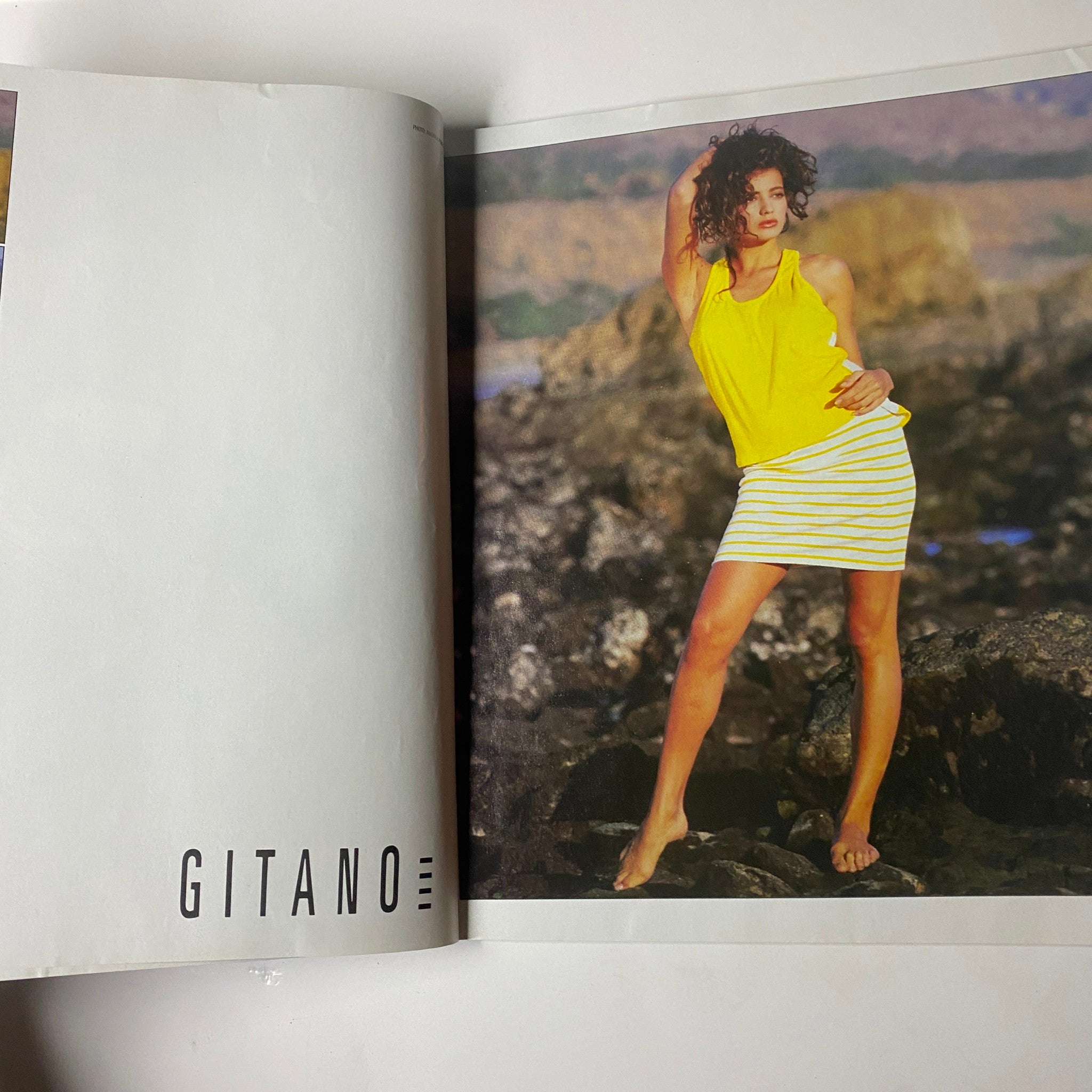 Fashion spread featuring a model in a yellow top and striped skirt from Gitano, captured in a natural outdoor setting.