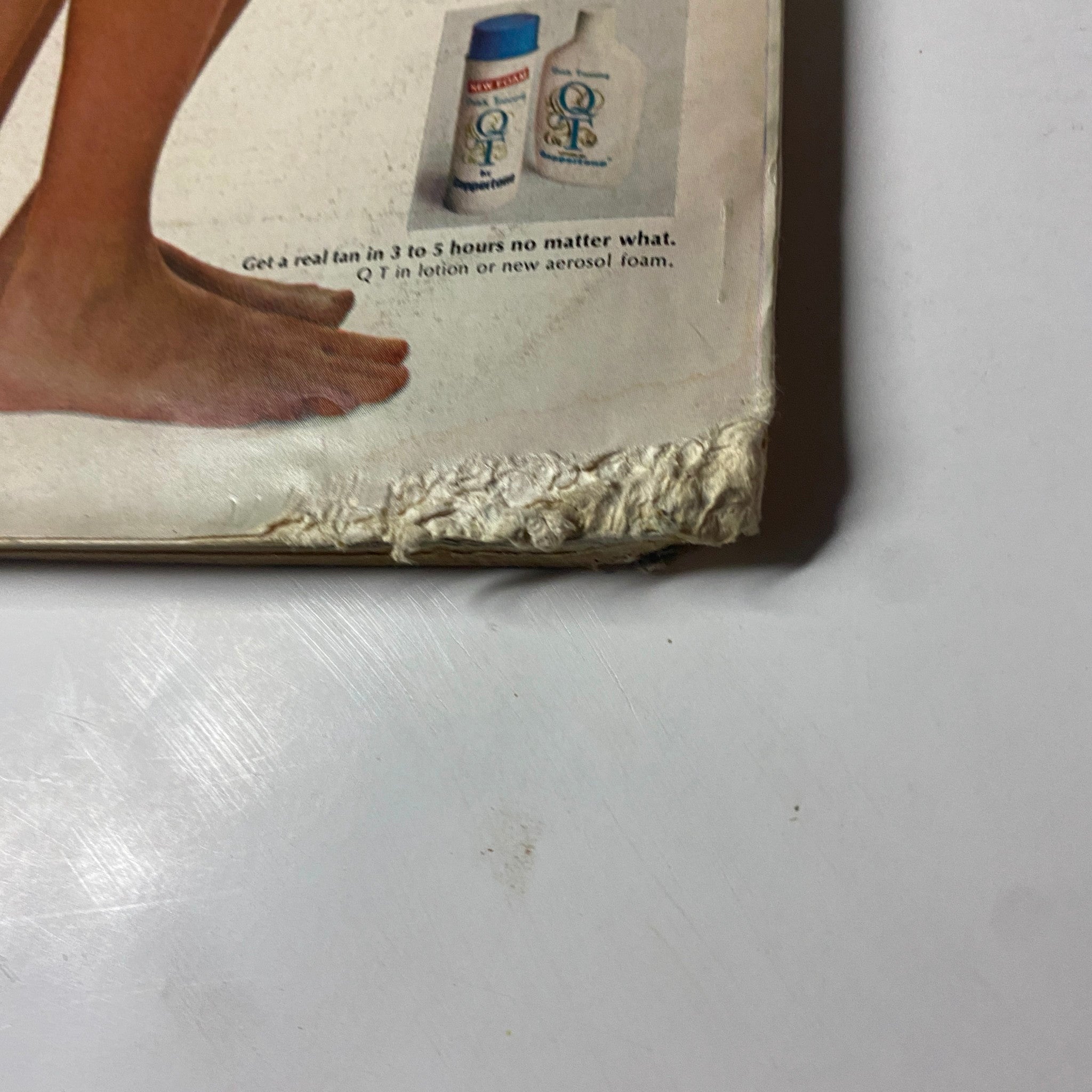 Close-up view of the edge of an advertisement from Cosmopolitan Magazine June 1972, showing wear and tear, indicative of its vintage status.