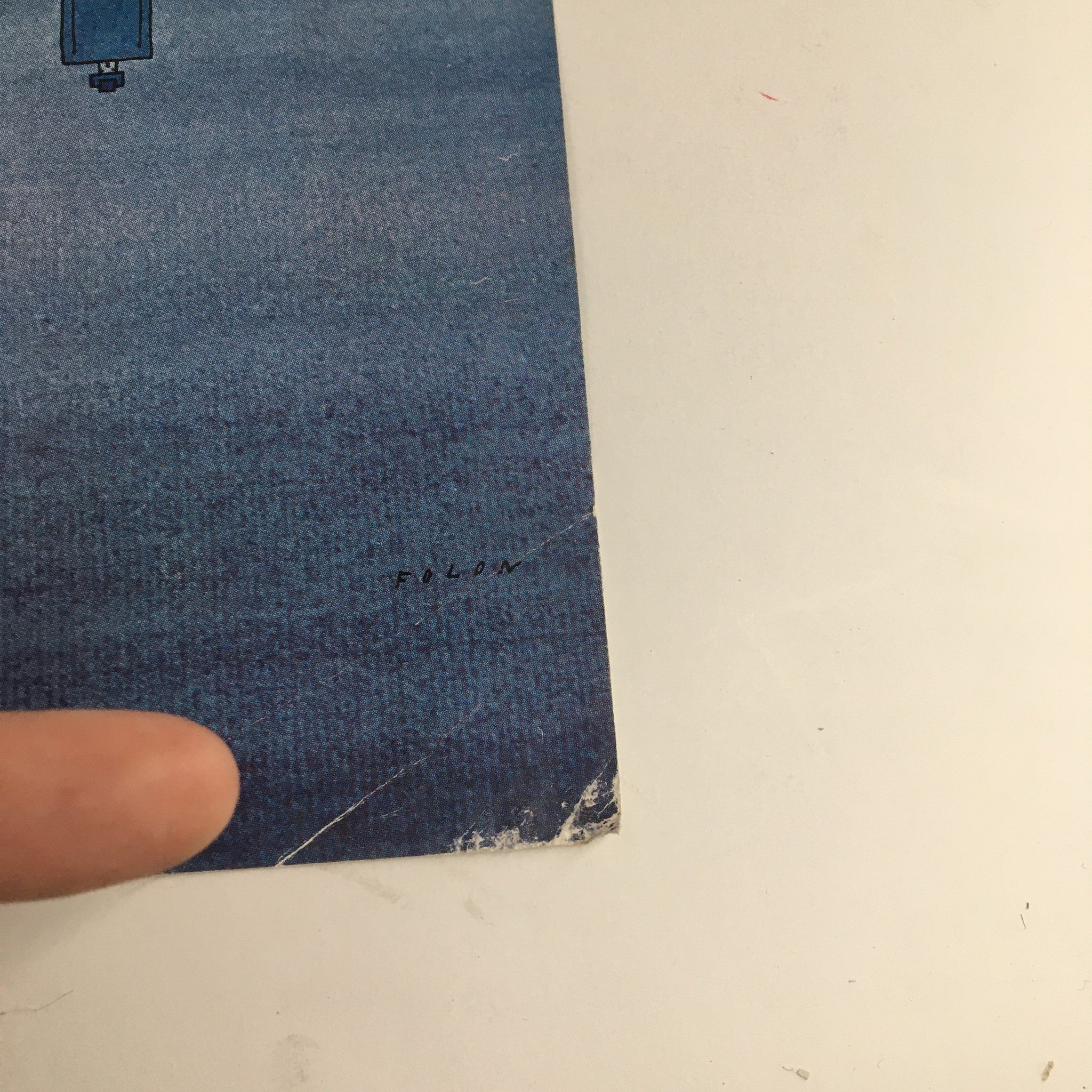 Close-up of the vintage New Yorker magazine cover from December 6, 1969, by Jean-Michel Folon, showcasing the signature and detail of the artwork against a blue backdrop.