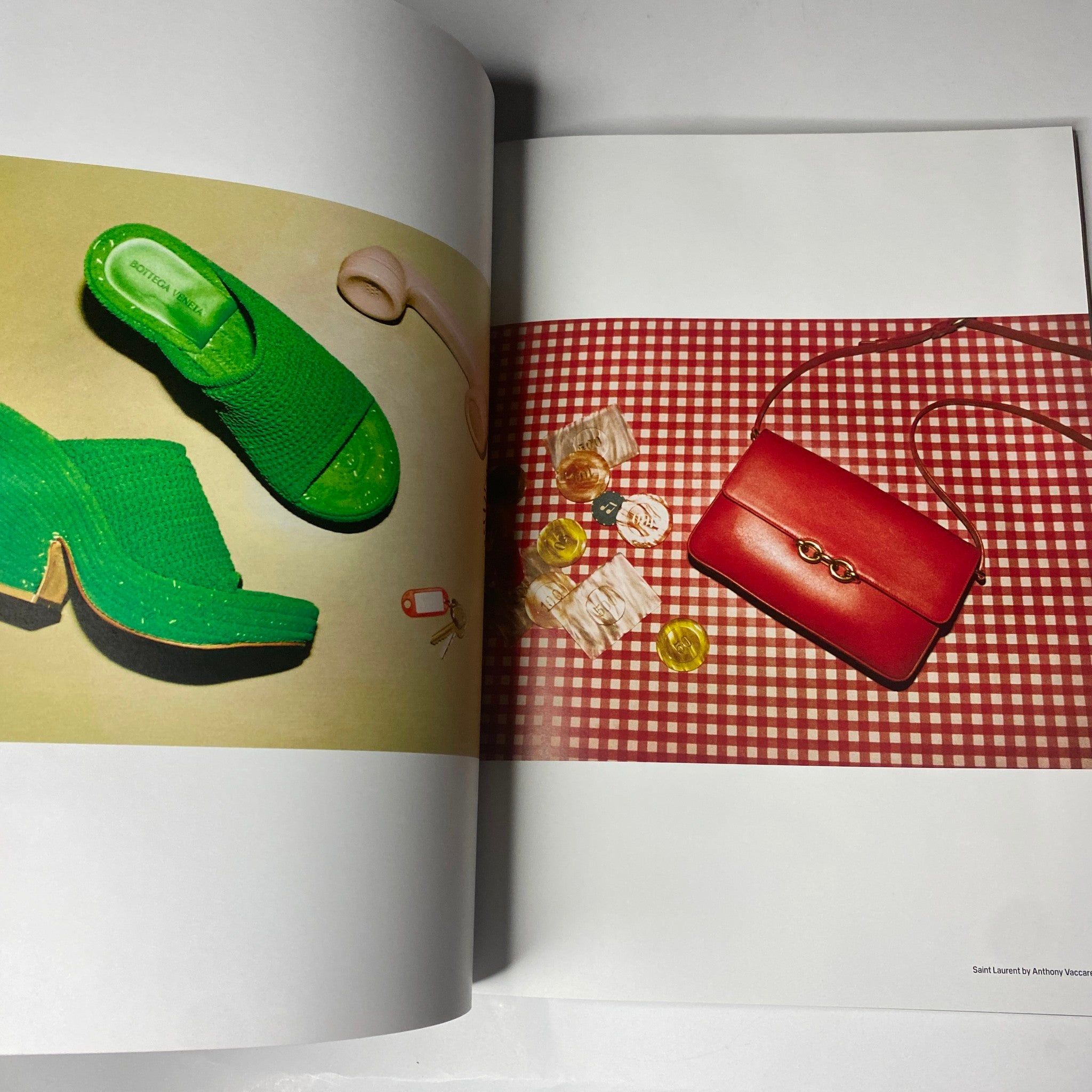 An editorial view from W Magazine 2021 Volume 1 featuring vibrant fashion items including green shoes and a red purse.