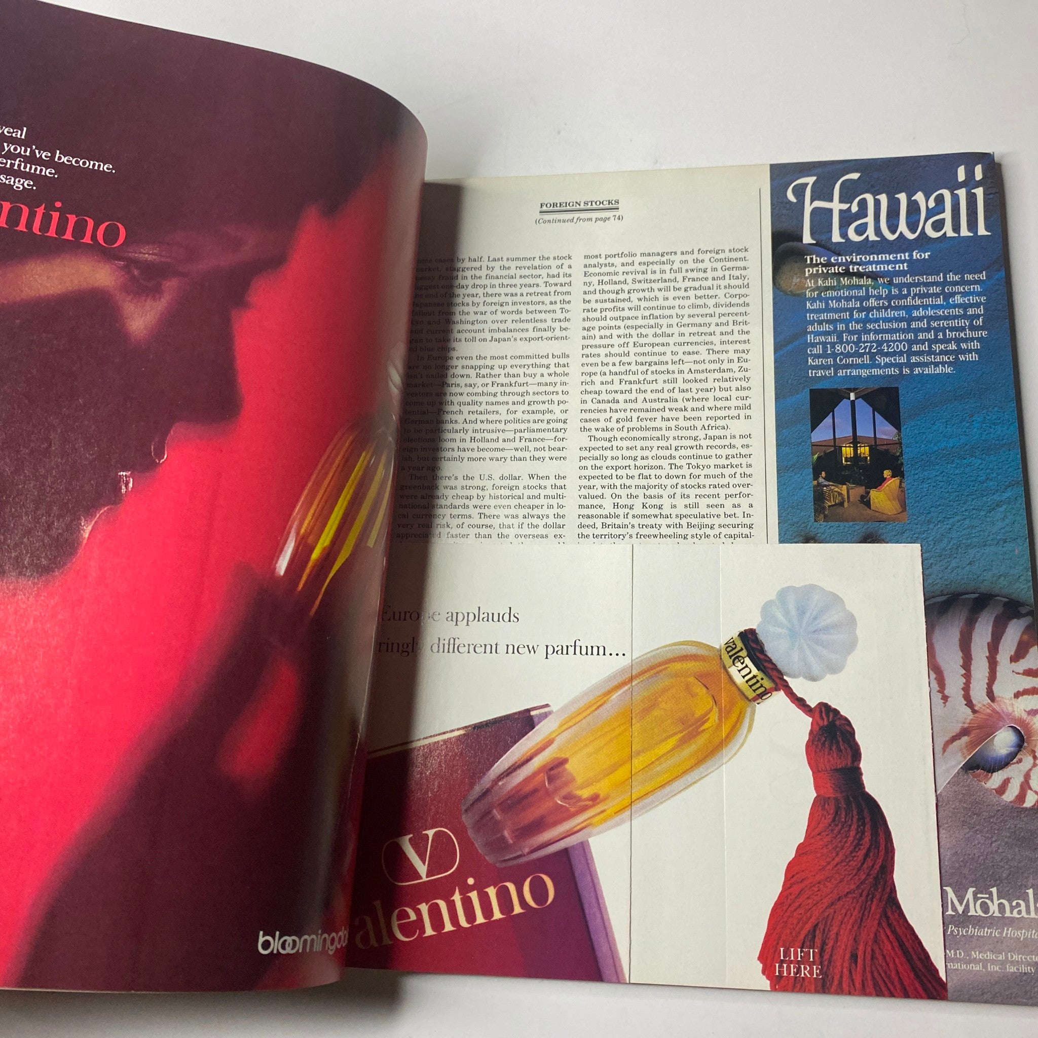 Two-page spread in Town & Country Magazine, March 1986, featuring a Valentino perfume advertisement alongside a scenic view of Hawaii. The vibrant imagery captures the essence of luxury fragrance and travel.