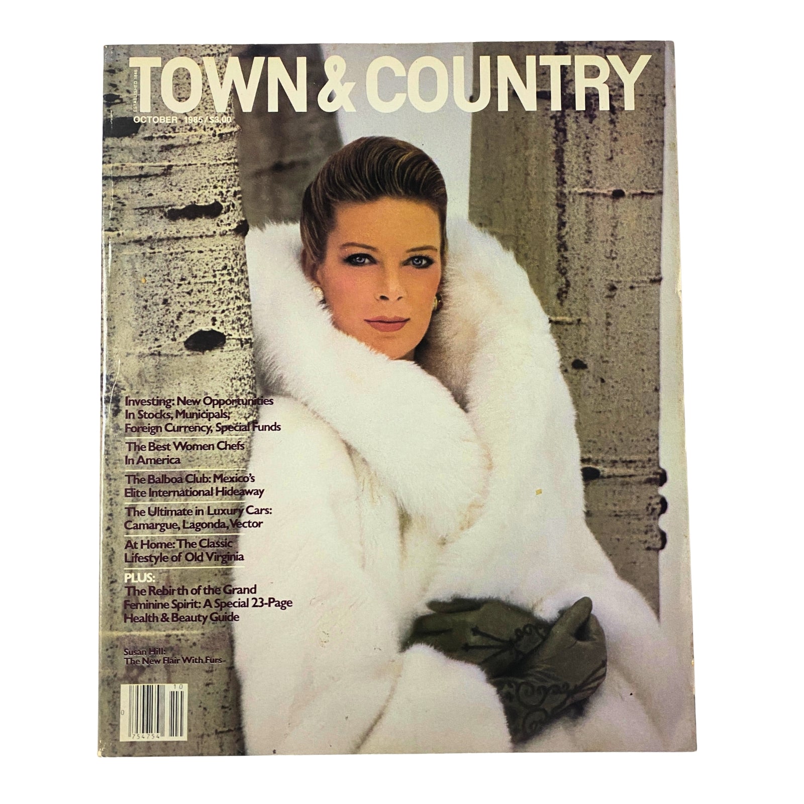 Town & Country Magazine October 1985 cover featuring Susan Hill in a luxurious white fur coat, exuding winter elegance against a serene outdoor backdrop.