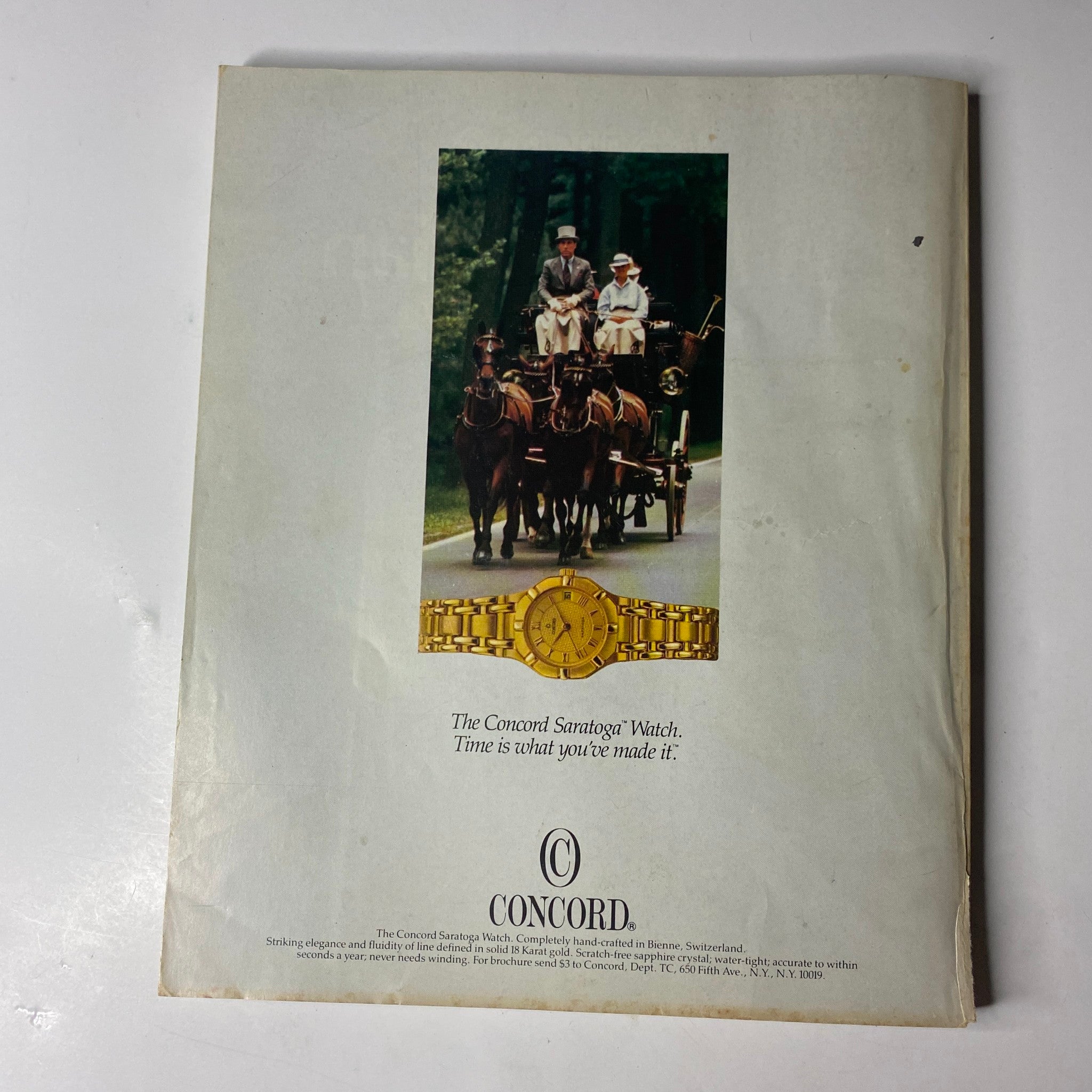 The back cover advertisement from the Town & Country Magazine October 1986 issue, featuring a horse-drawn carriage and a luxury Concord watch, promoting the theme of elegance and timelessness.