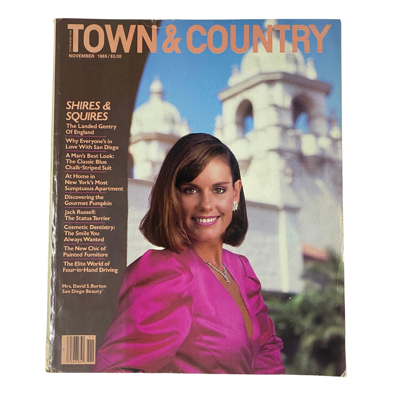 Town & Country Magazine November 1985 cover featuring Sarah Burton in a bright pink two-piece suit, showcasing California elegance against the backdrop of Balboa Park.