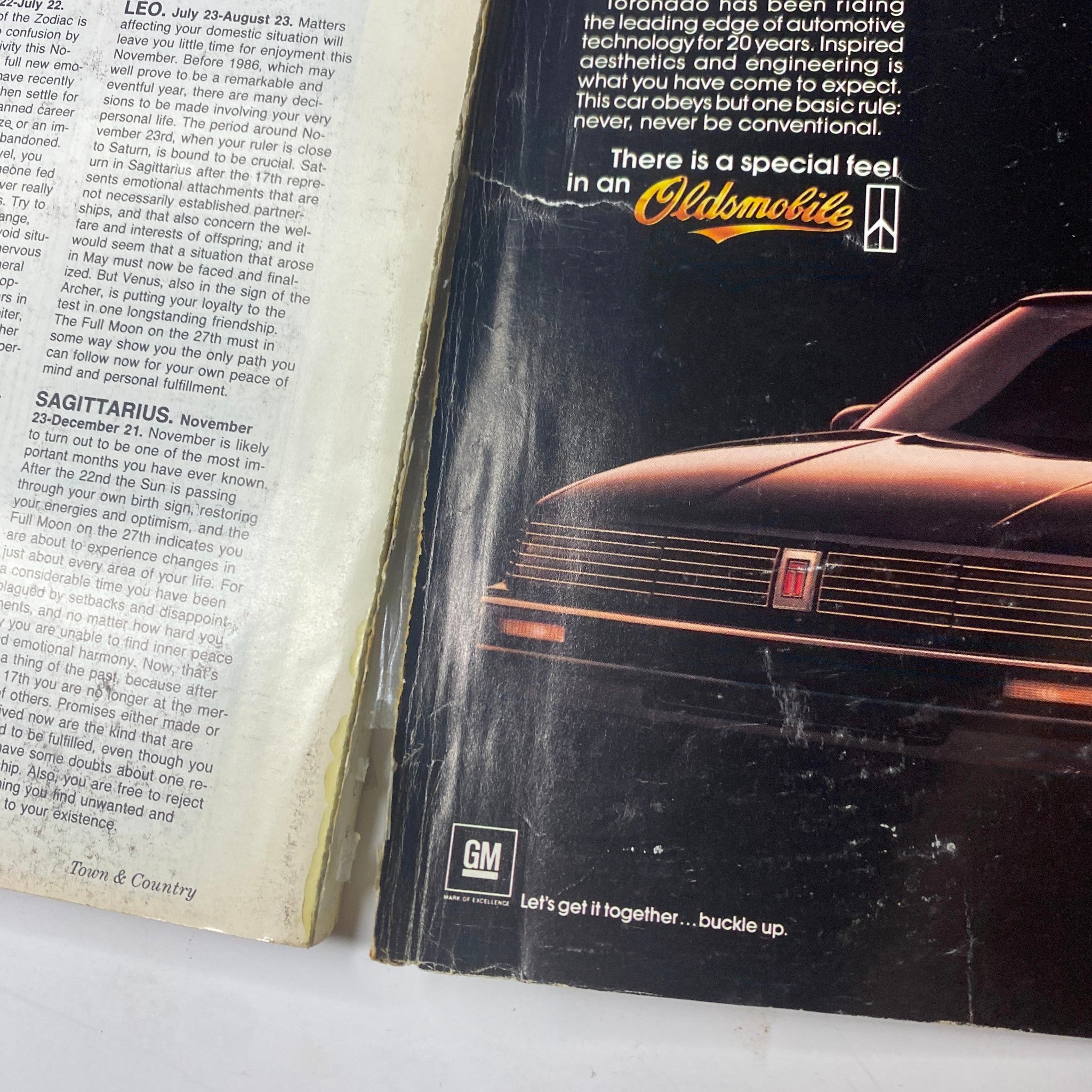 Town & Country Magazine November 1985 showing a page with an Oldsmobile advertisement, highlighting the unique feel of driving an Oldsmobile, complemented by a stylistic design. No Label.