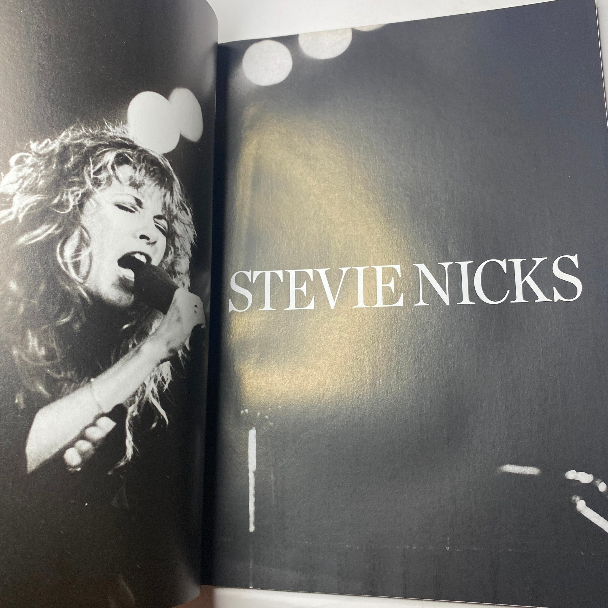 Inside page of 'Stevie Nicks Photo Book' featuring a striking black and white image of Stevie Nicks performing, showcasing her intensity and charisma on stage.