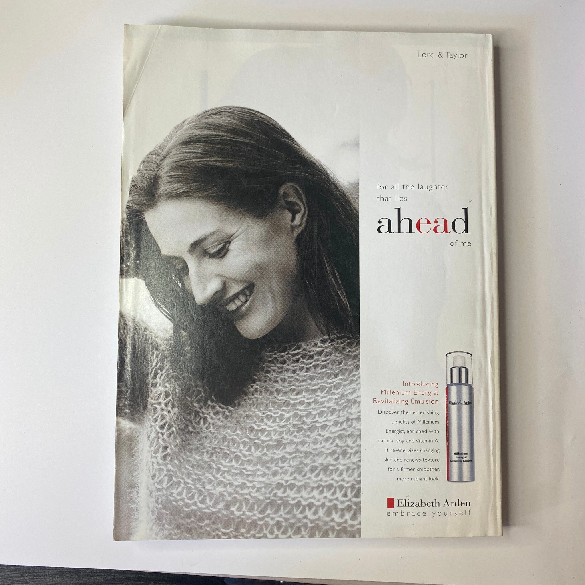 Vogue Magazine October 1999 Winona Ryder Cover presenting a vintage advertisement for Elizabeth Arden skincare, featuring a woman smiling warmly, promoting energy and youthful appearance.