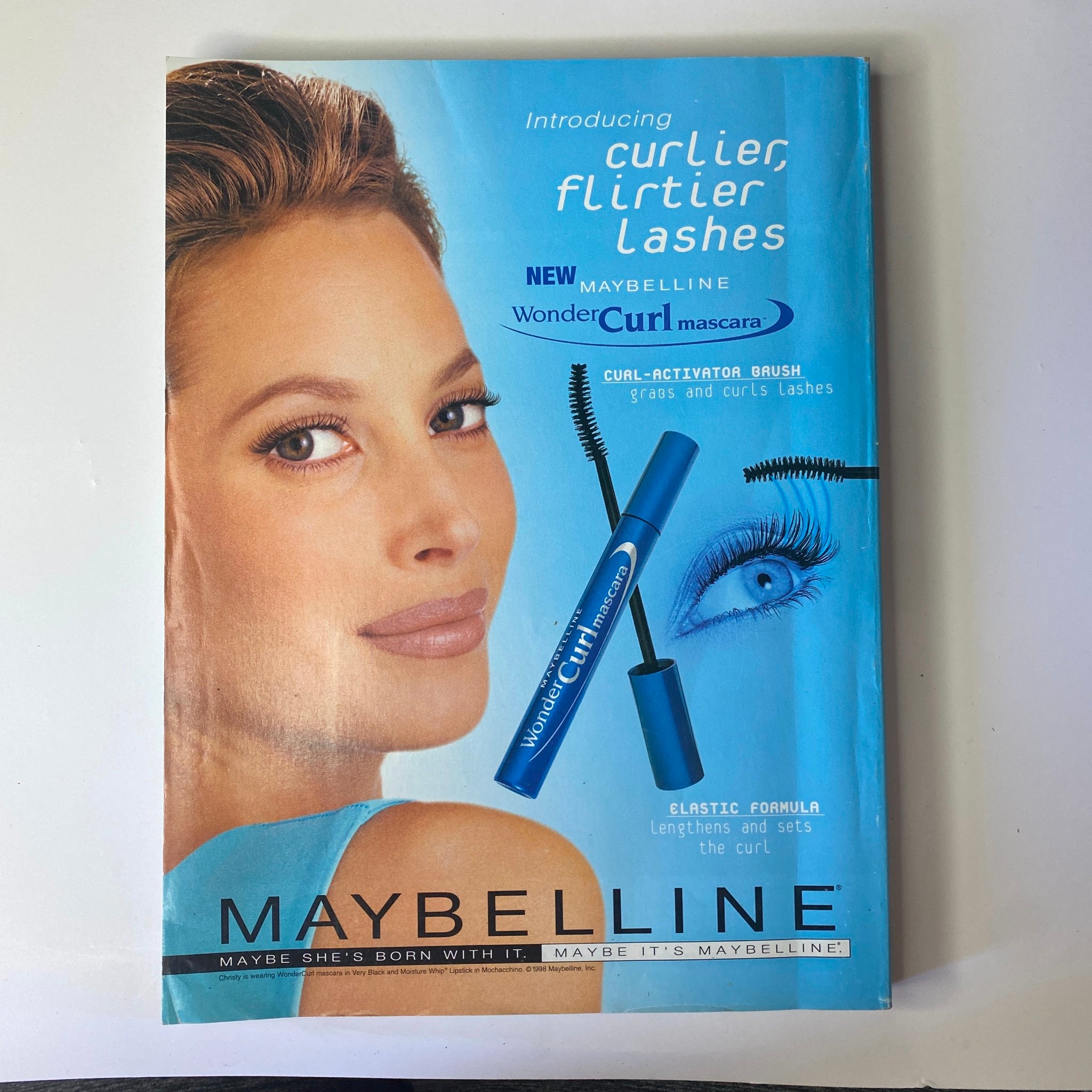 Advertisement from Vogue Magazine April 1999 introducing Maybelline's Wonder Curl Mascara, featuring a model with beautifully styled lashes, promoting beauty and makeup products.