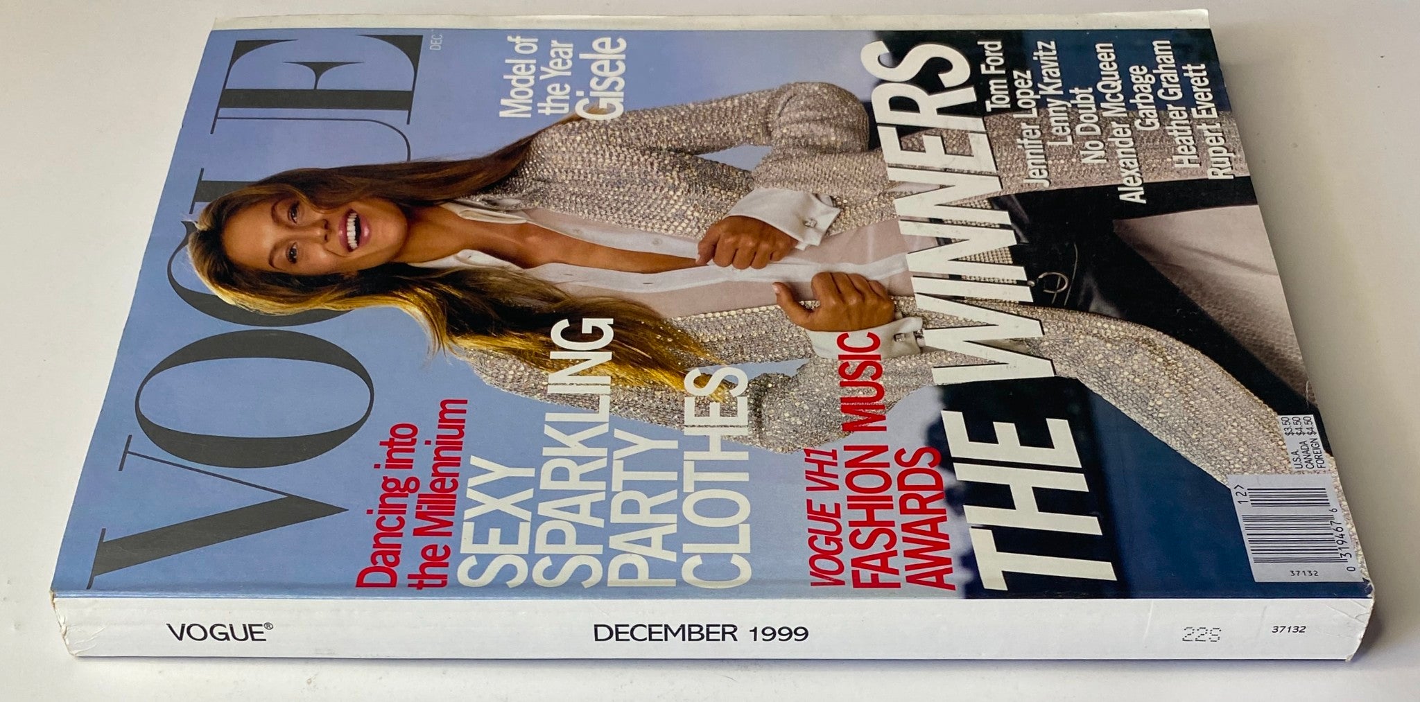 Side view of the December 1999 Vogue Magazine cover showcasing Gisele Bündchen as Model of the Year, with headlines highlighting 'Dancing into the Millennium' and 'The Winners' of the Vogue/VH1 Fashion Music Awards.
