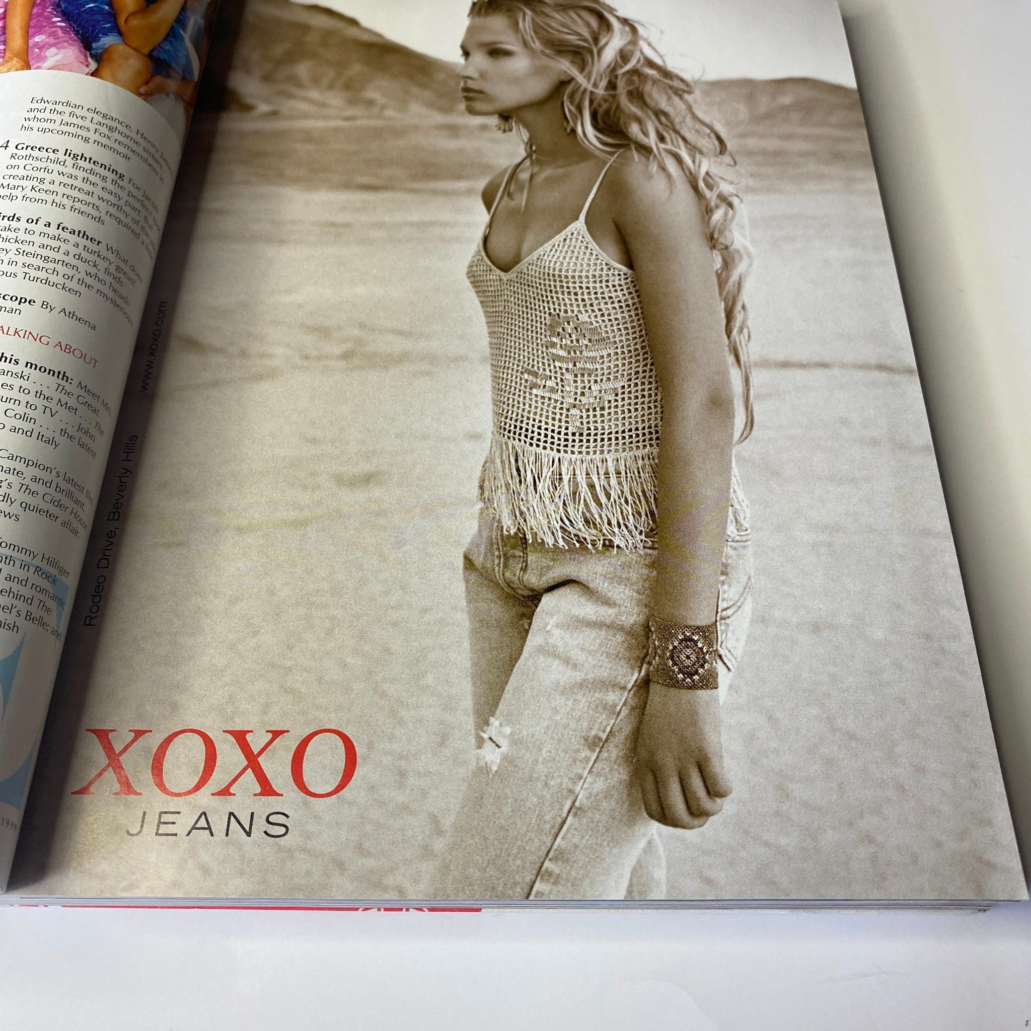 Vogue Magazine December 1999 Gisele Bündchen Cover - A fashion photograph featuring a model in XOXO jeans with a fringed top, showcasing late 1990s style.