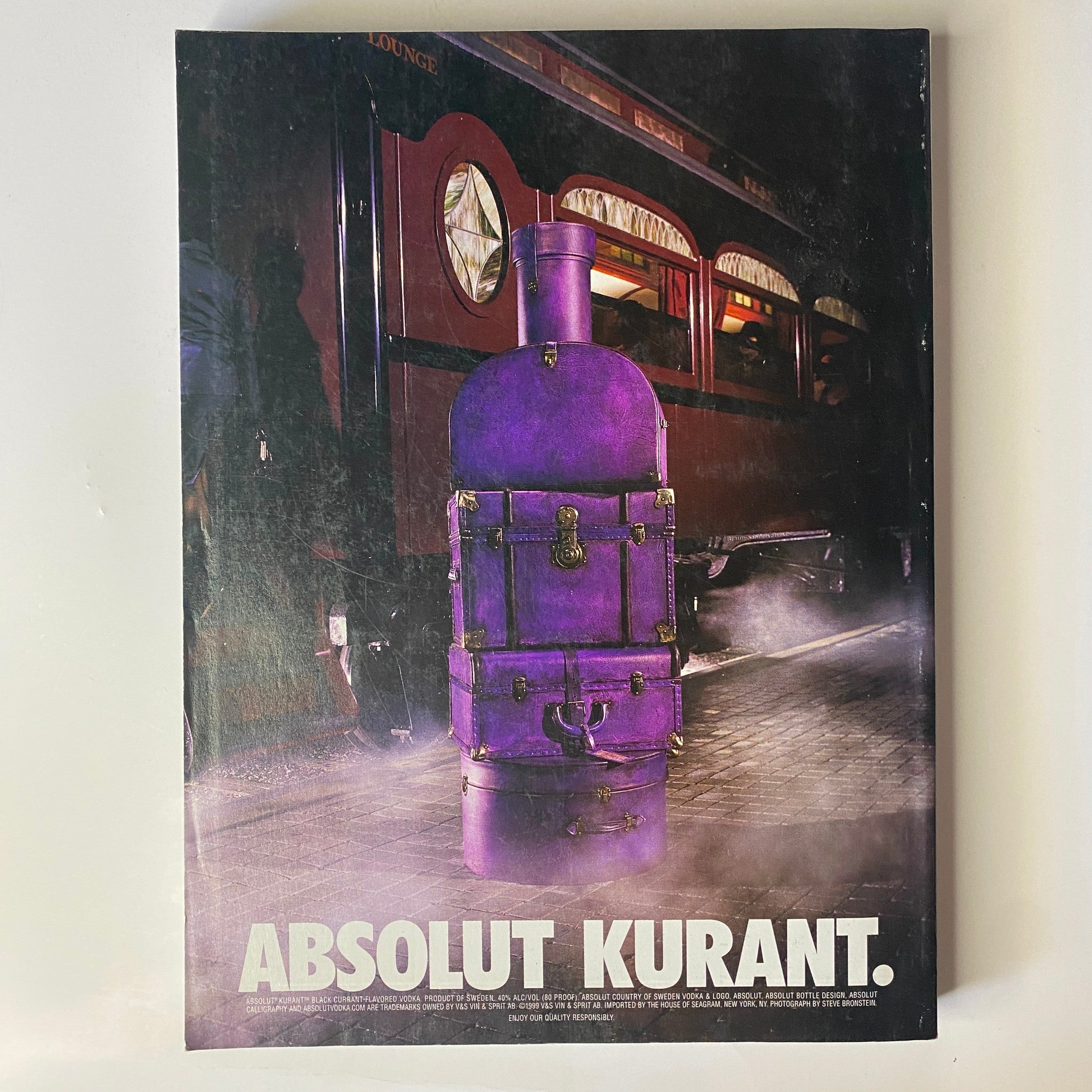 Vogue Magazine December 1999 Gisele Bündchen Cover - A striking advertisement for Absolut Kurant featuring a vintage purple stove, set against a moody, atmospheric background.