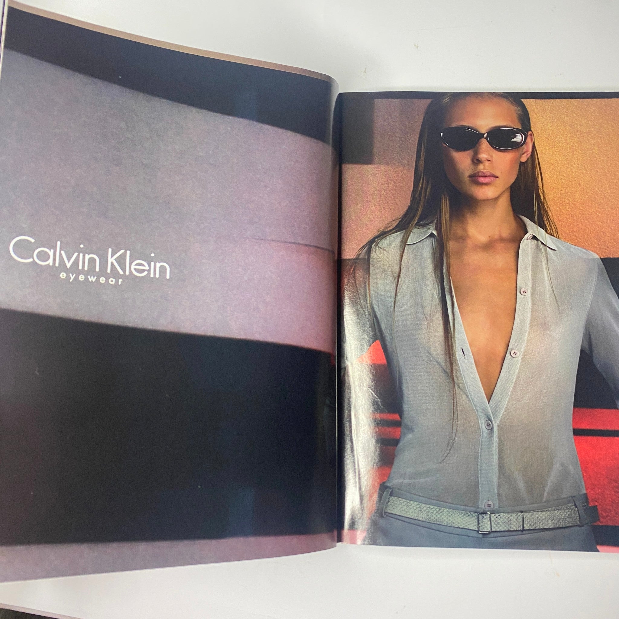 Vogue Magazine May 2000 Gisele Bündchen Cover with a Calvin Klein eyewear advertisement displaying a model in a stylish, form-fitting shirt and trendy sunglasses, highlighting contemporary fashion.