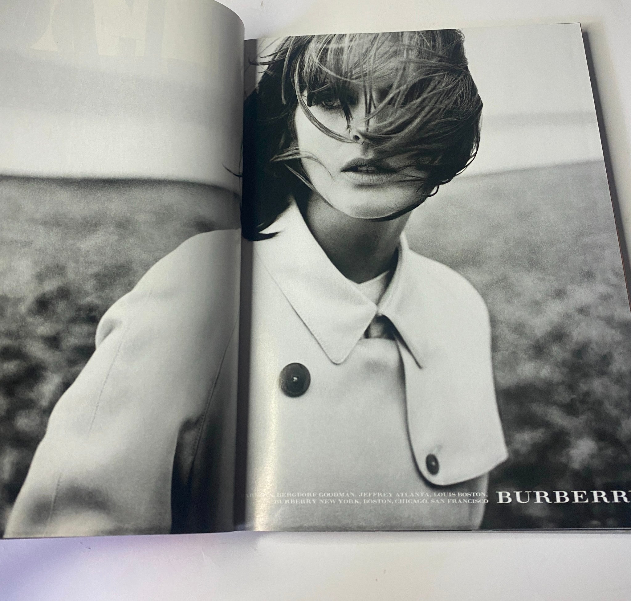 Vogue Magazine February 1999 showcasing an advertisement for Burberry featuring a black and white image of a model with wind-swept hair, emphasizing fashion and style.