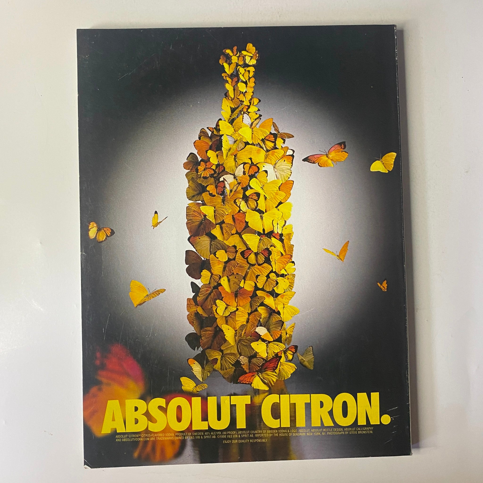 Vogue Magazine February 1999 cover of the Absolut Citron advertisement, featuring a striking artwork of a bottle made of butterflies, highlighting brand creativity.