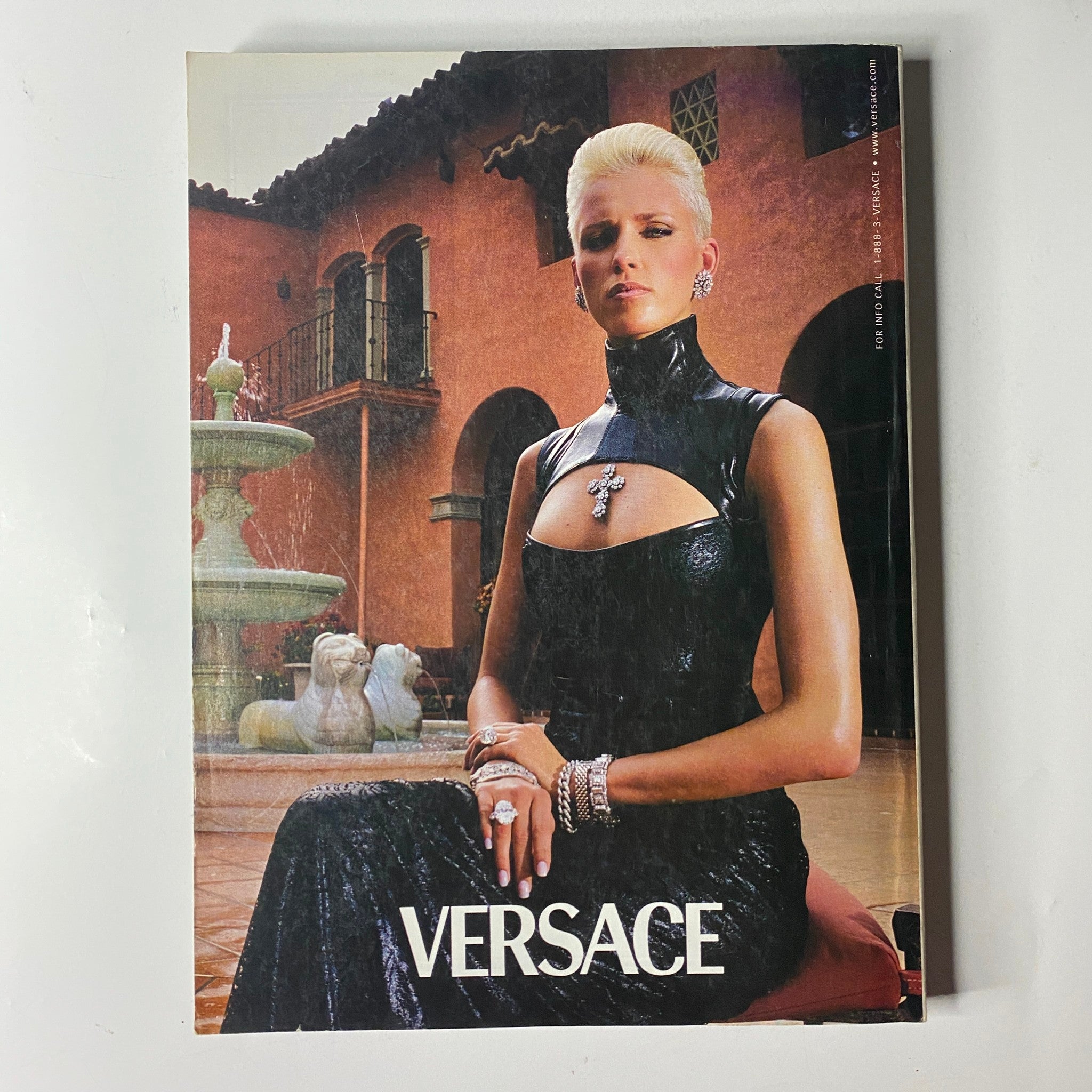 Versace advertisement from Vogue Magazine October 2001 featuring a striking model in a glamorous outfit, representing high-end fashion and luxury.