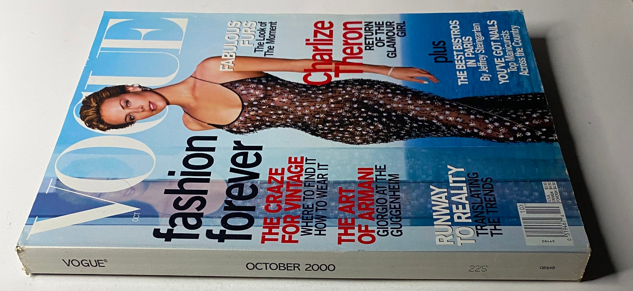 Vogue Magazine October 2000 - Charlize Theron Cover showcasing a glamorous layout highlighting fashion and beauty themes, in very good condition.