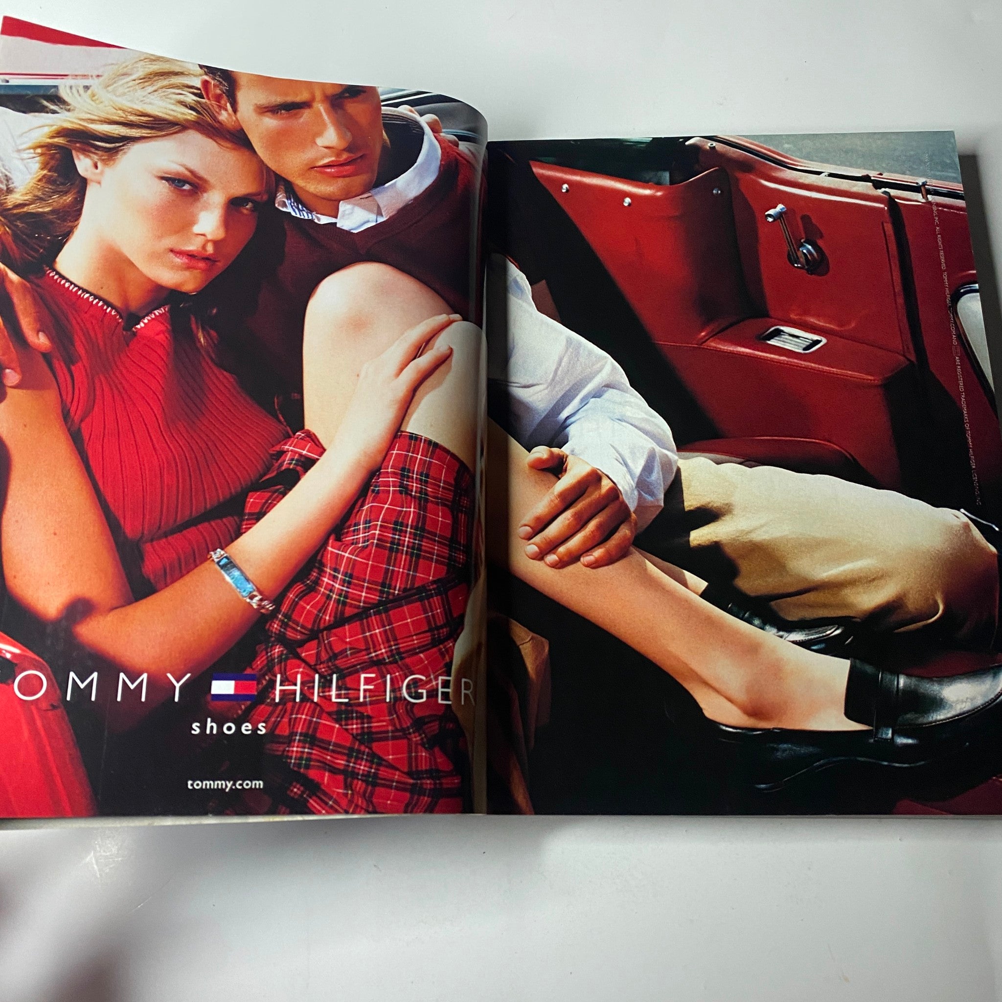 Tommy Hilfiger advertisement from Vogue Magazine October 2000 presenting a fashionable couple in a vibrant car, capturing the essence of youthful style.