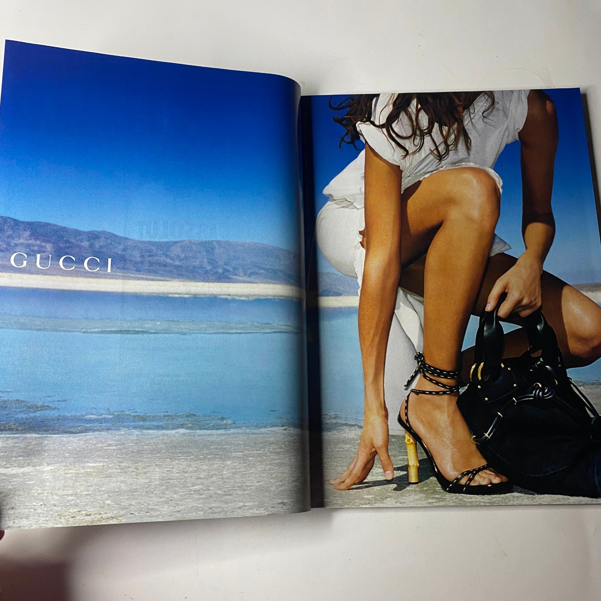 Vogue Magazine February 2002 Sarah Jessica Parker Cover No Label showcases a Gucci advertisement with a model in a striking beach setting, emphasizing contemporary fashion aesthetics.