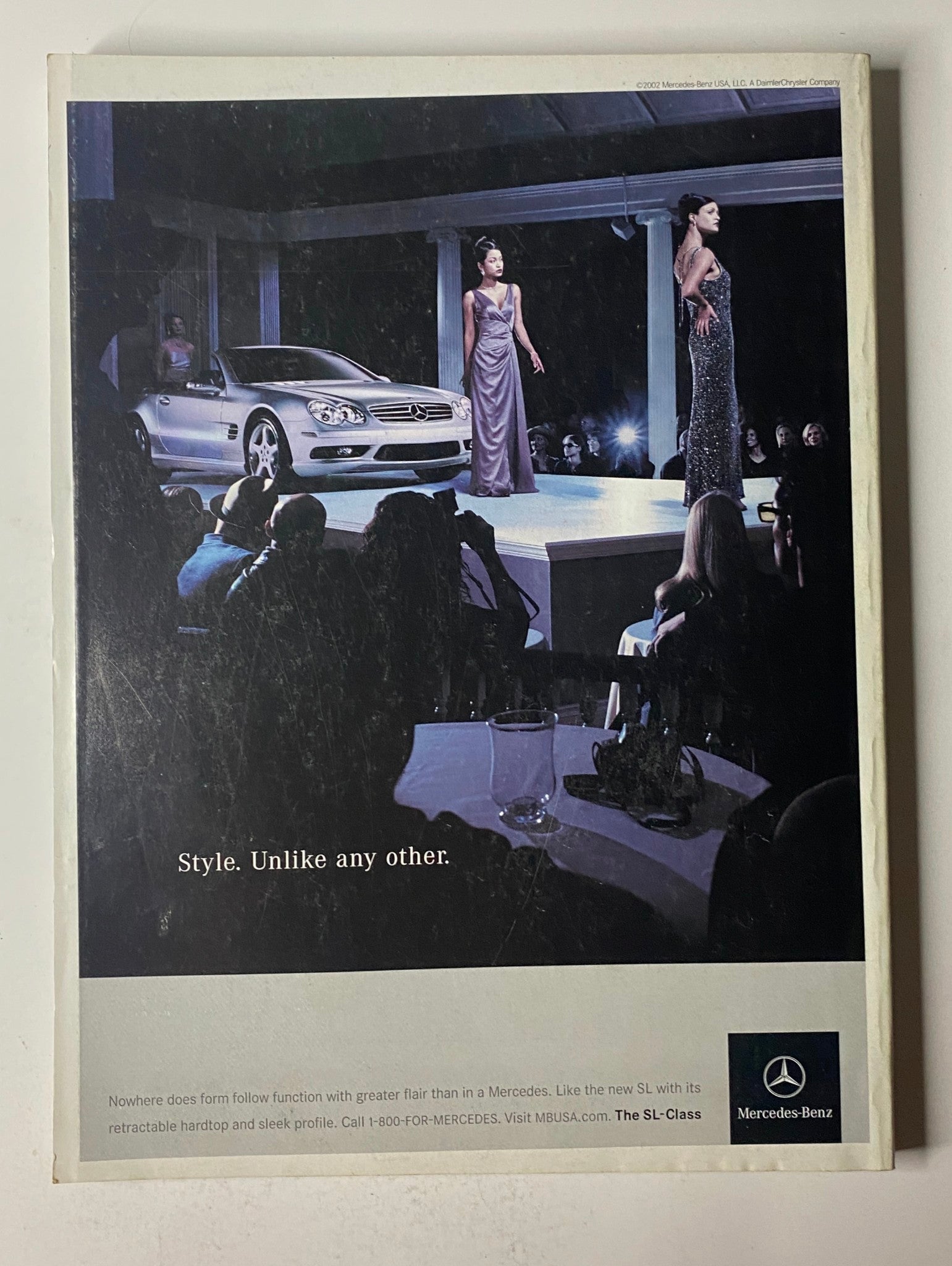 Mercedes-Benz advertisement featuring a fashion show with models walking on the runway alongside a Mercedes SL-Class car, showcasing luxury style in Vogue Magazine May 2002 cover featuring Natalie Portman.