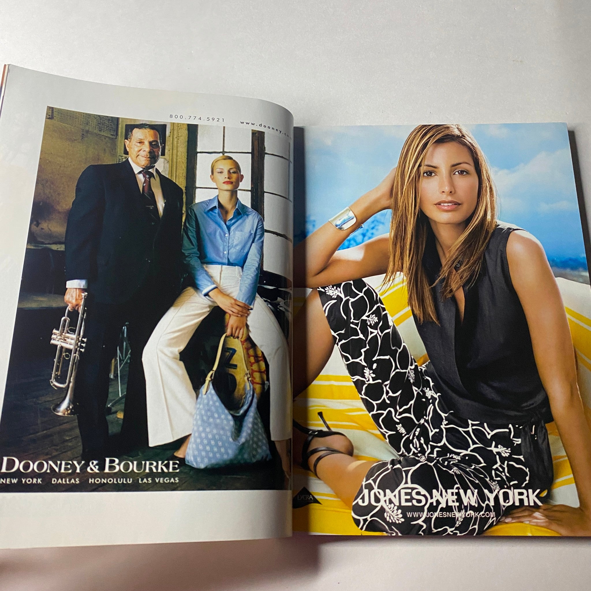 Vogue Magazine June 2002 page featuring a Dooney & Bourke advertisement, highlighting stylish accessories with models in a vibrant outdoor setting.