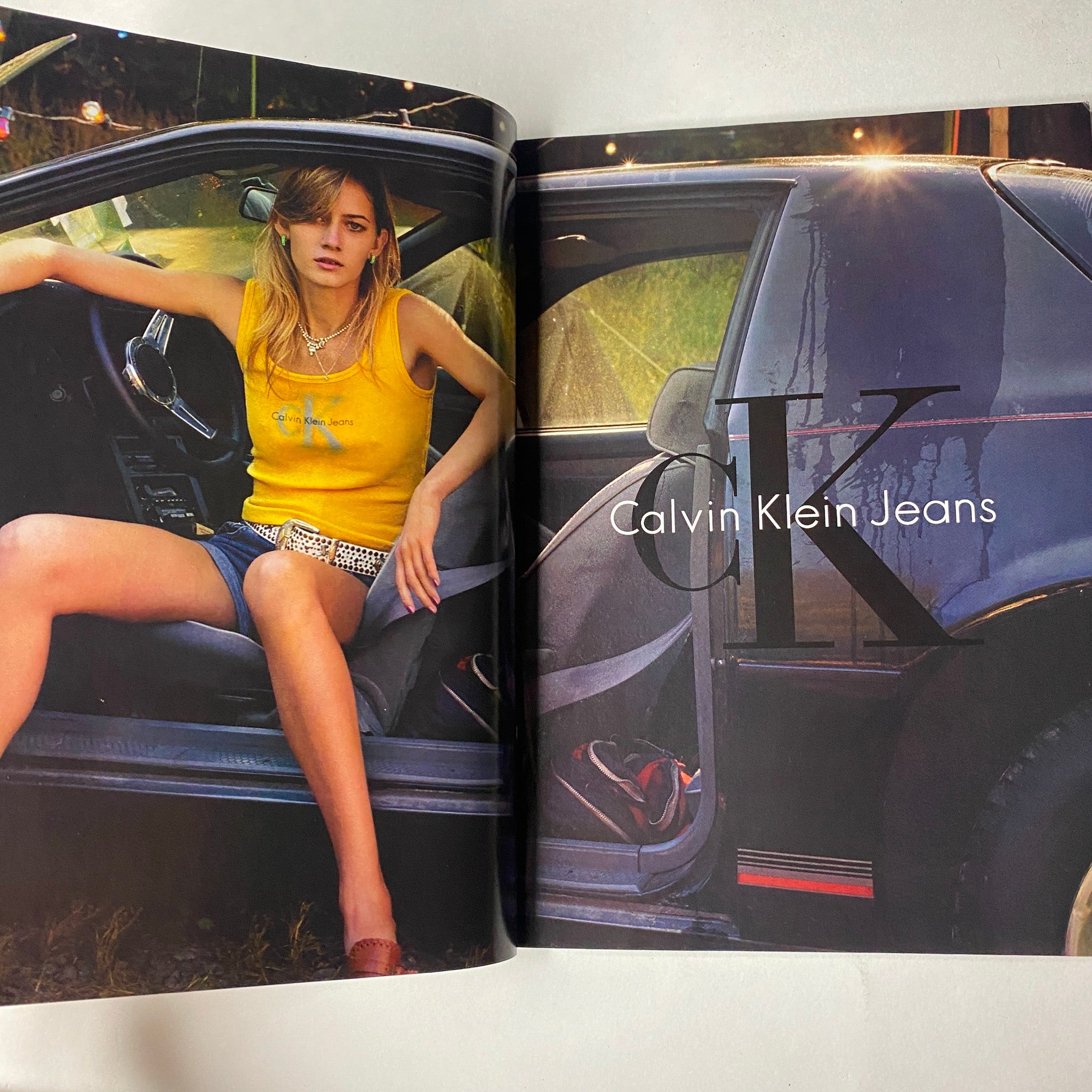 Advertorial spread in Vogue Magazine June 2001 showcasing Calvin Klein Jeans with a model in a vintage car, highlighting trendy fashion and youthful aesthetics.