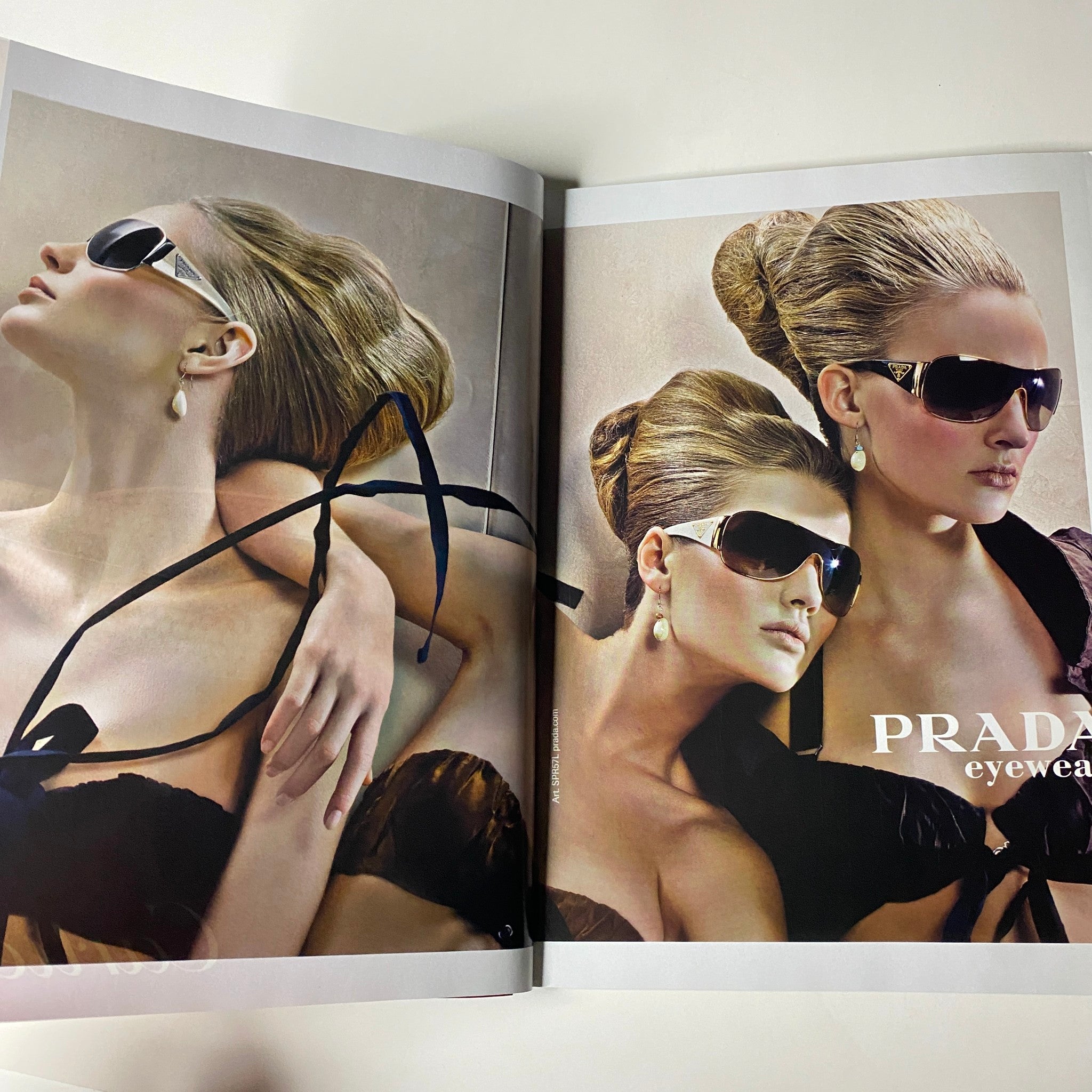 Advertisement spread for Prada in Vogue Magazine June 2009, showcasing stylish eyewear with high-fashion aesthetics featuring models in elegant settings.