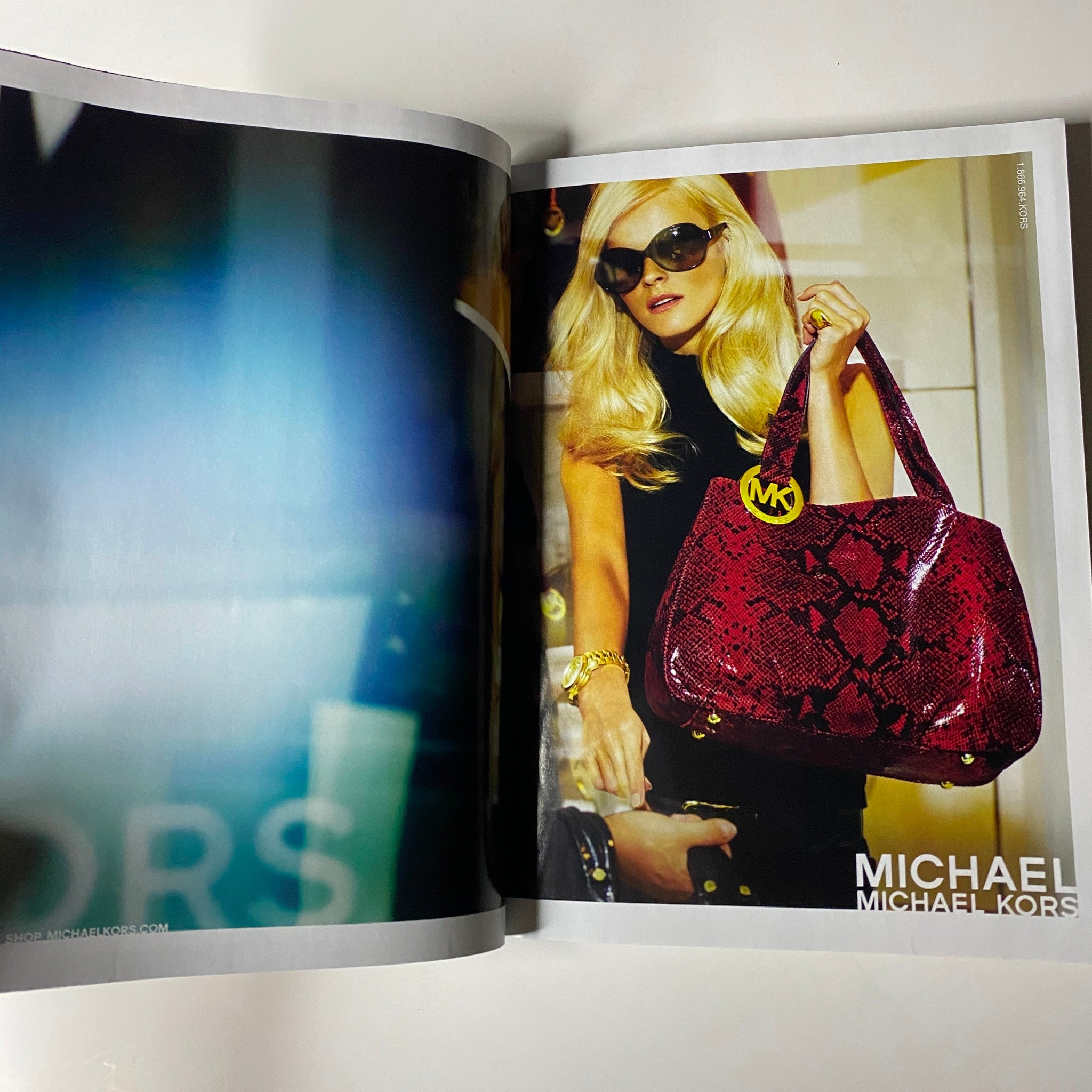 An advertisement featuring a stylish blonde model holding a red snakeskin Michael Kors bag. The image is from Vogue Magazine December 2009, representing luxury fashion and accessories.