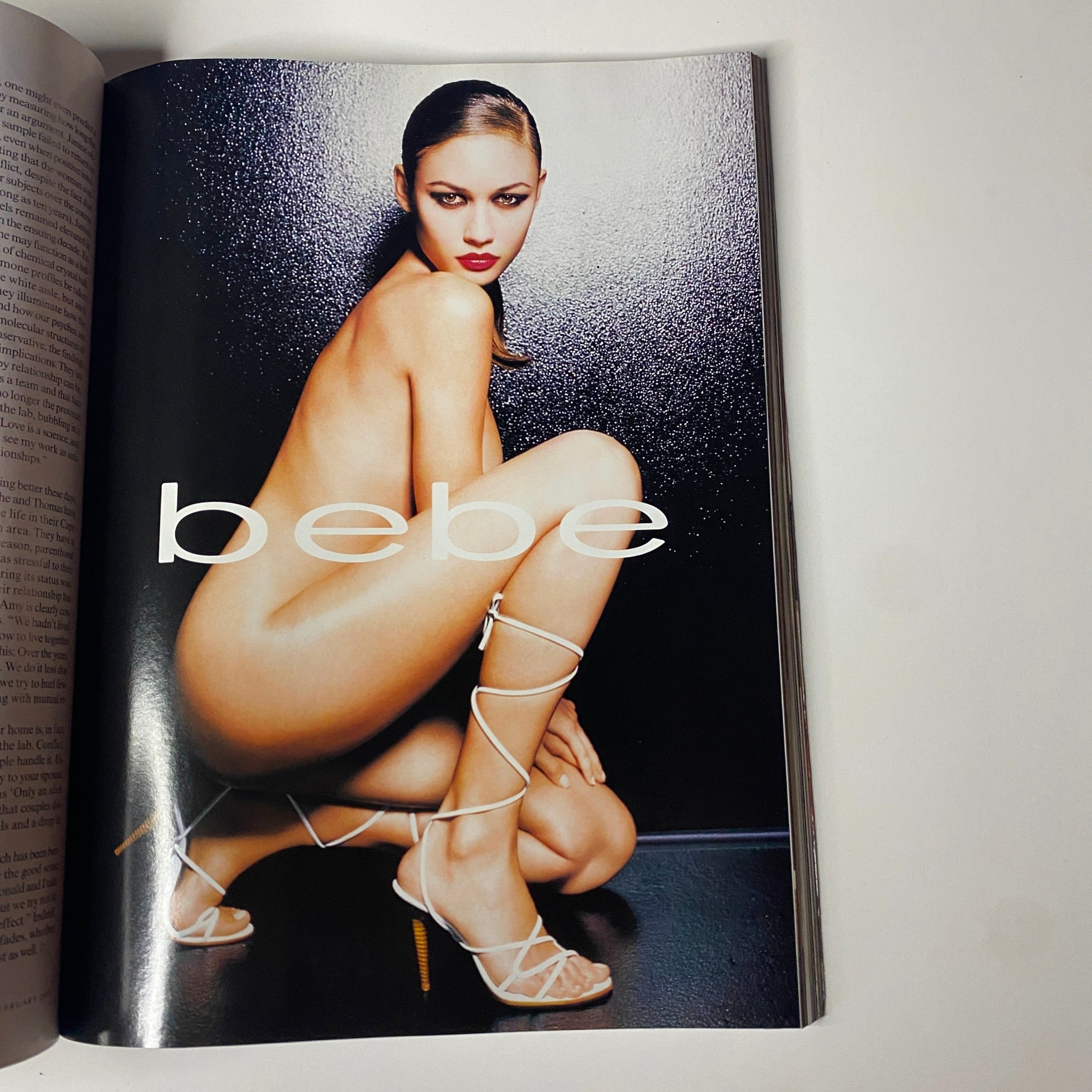 Fashion photography featuring a model in a striking pose wearing stylish footwear, from Vogue Magazine February 2003 Debra Messing Cover. This editorial showcases modern fashion trends and seductive aesthetics.