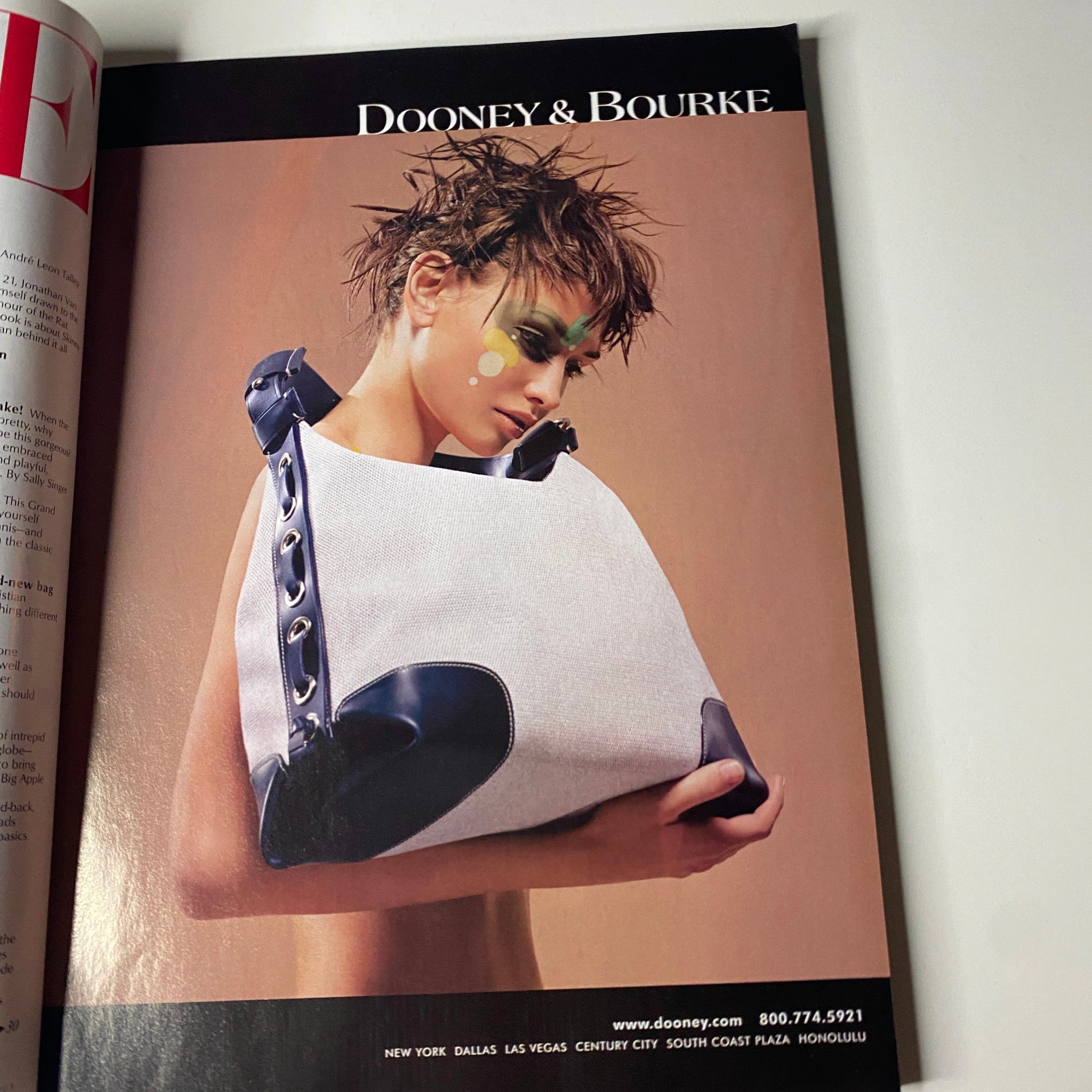 Dooney & Bourke advertisement featuring a model showcasing a stylish handbag, from Vogue Magazine June 2003 Reese Witherspoon Cover No Label.