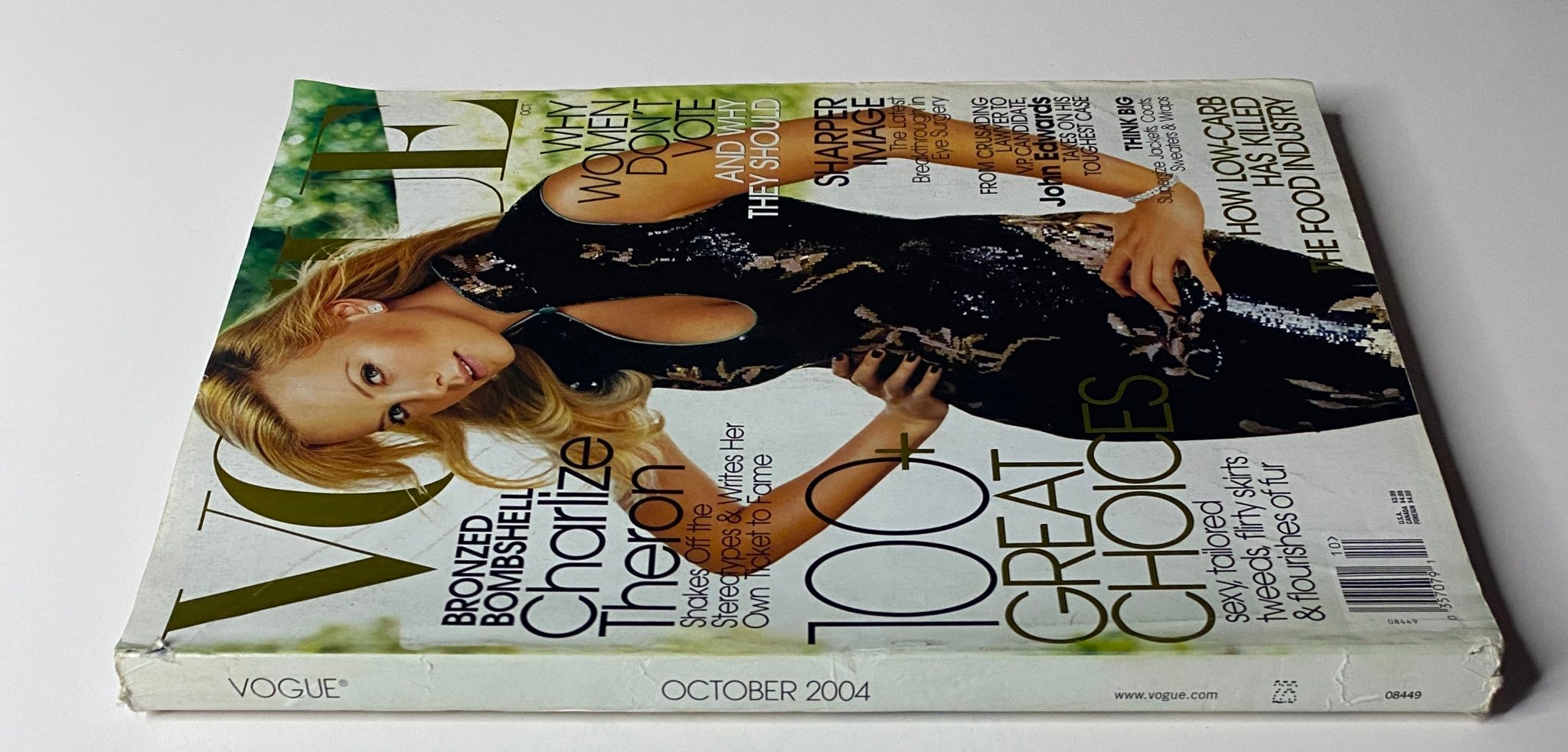 Side view of Vogue Magazine October 2004 with Charlize Theron on the cover, highlighting the title 'Bronzed Bombshell' and the issue's key features, including 'Why Women Don't Vote'.